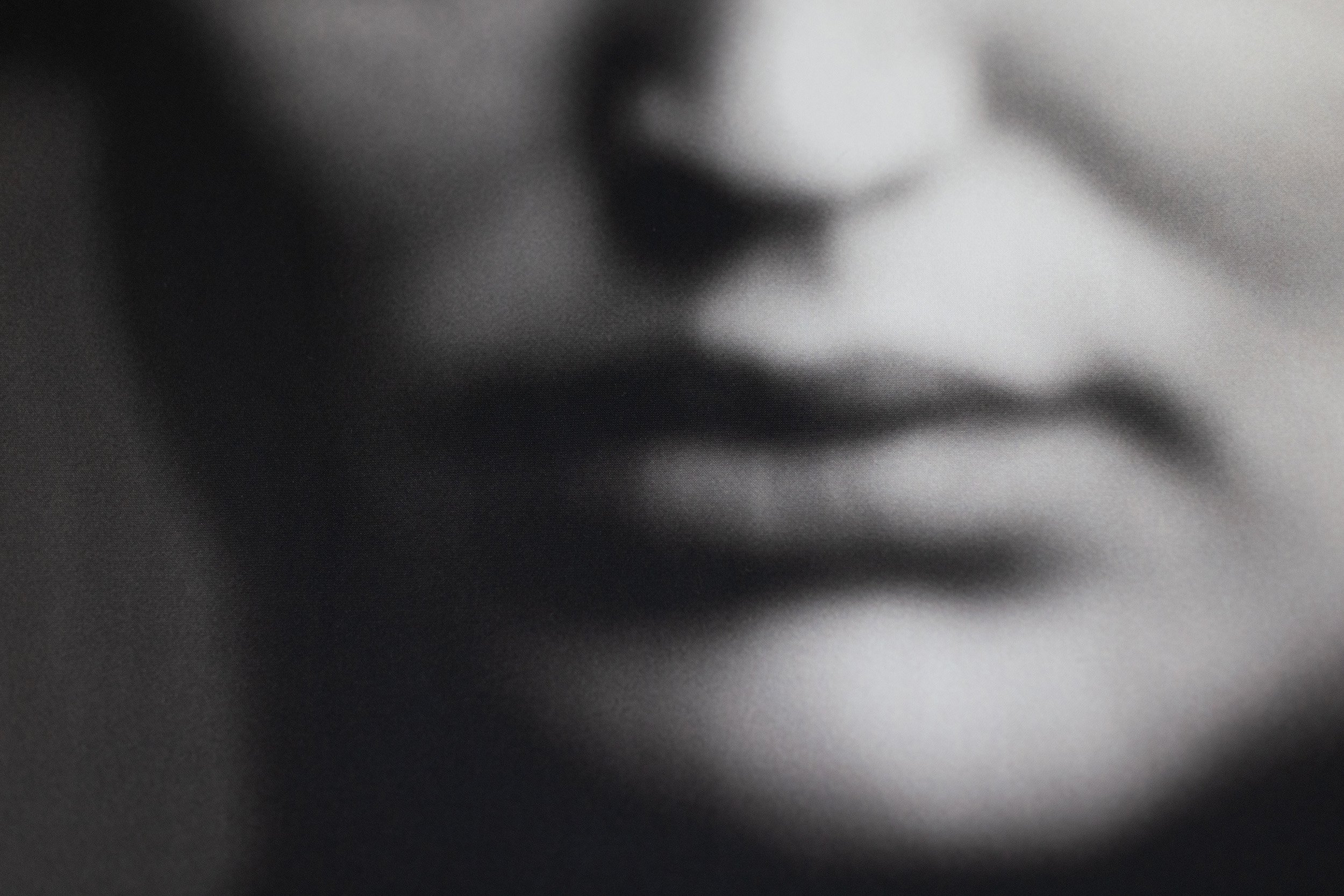 Nahaufnahme eines menschlichen Gesichts im Schwarz-Weiß-Stil, mit Fokus auf die Lippen und den Mund.