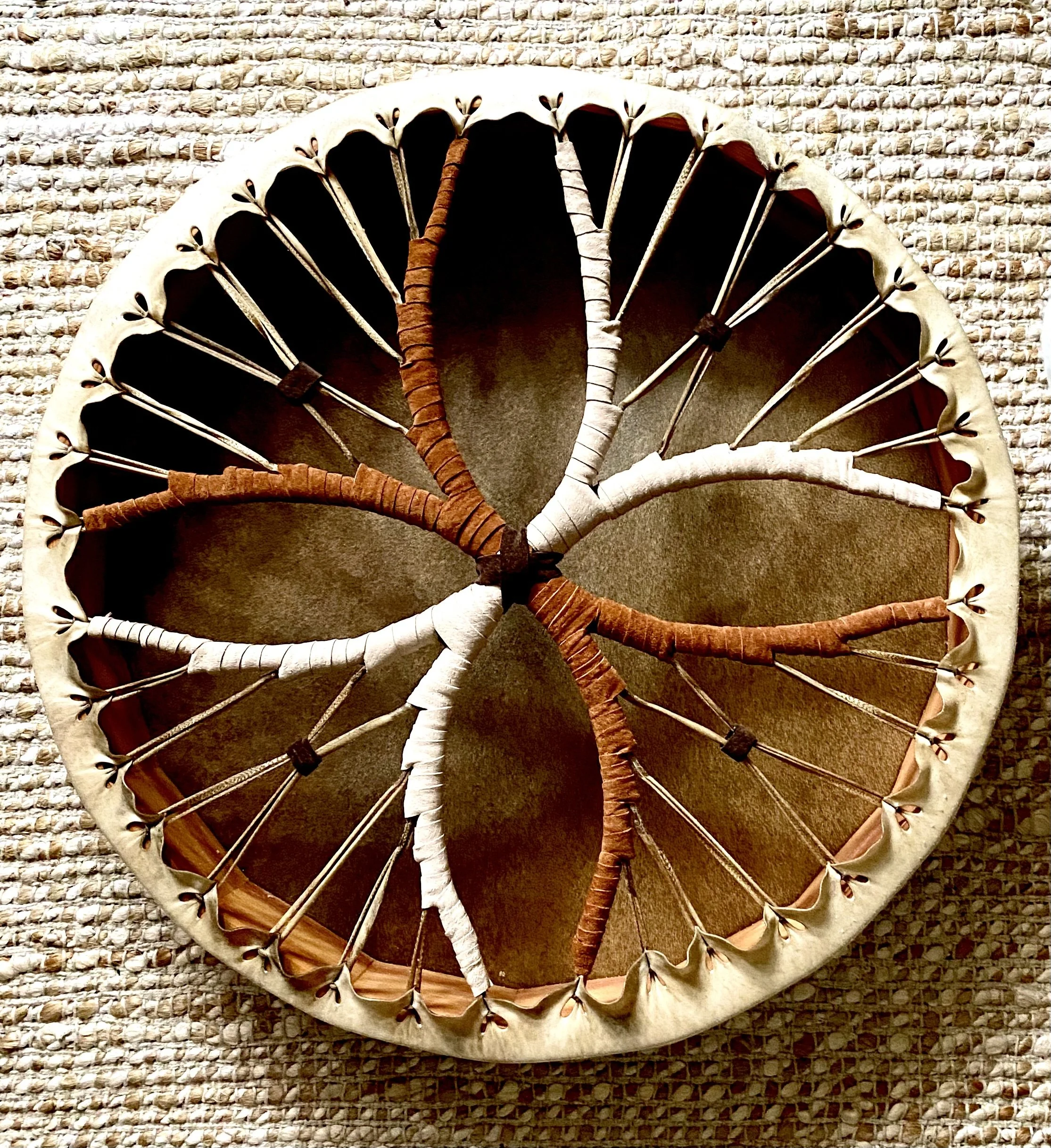 Decorative umbrella with fabric and wire design, placed on a textured woven surface.