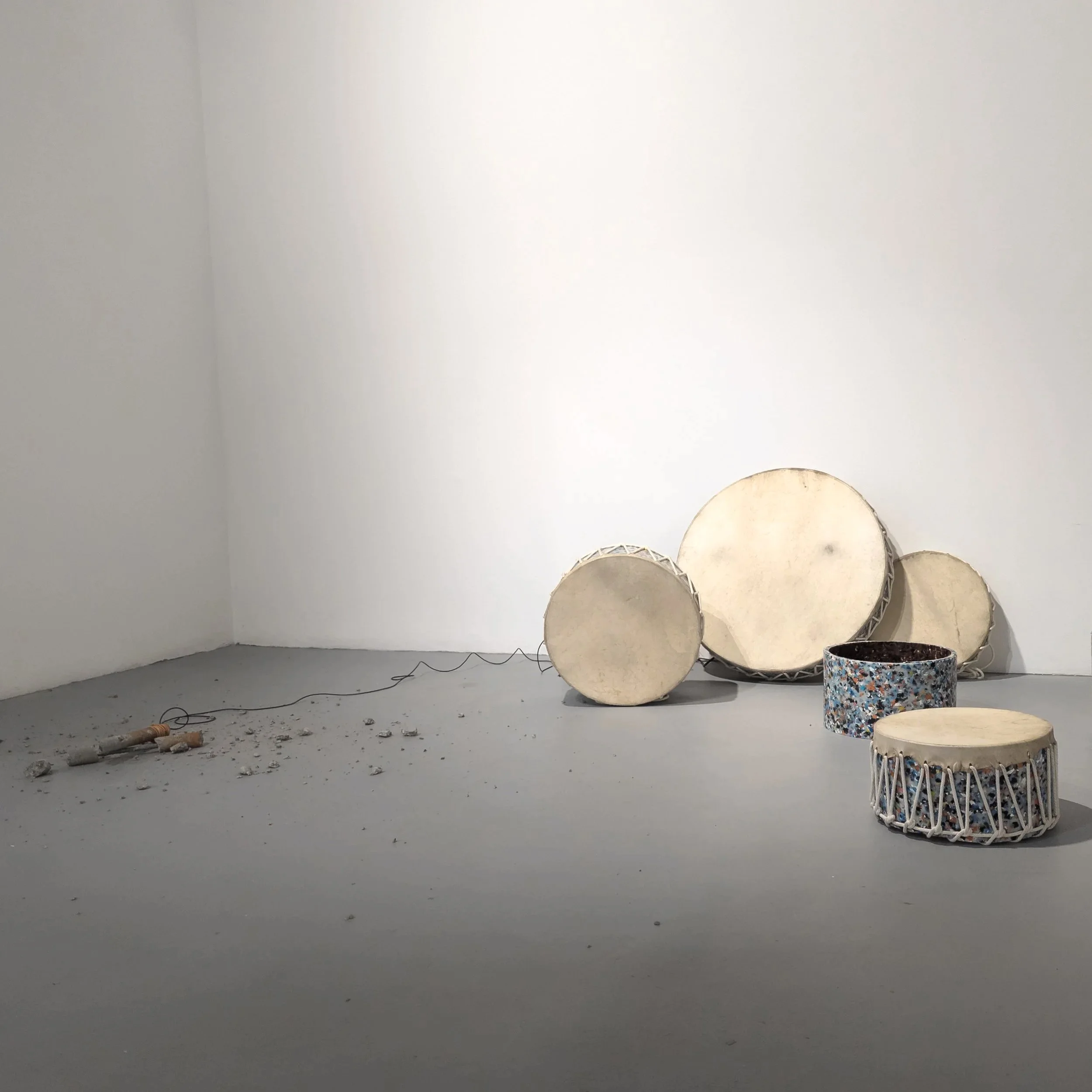 Example of previous work - Bang Bang, 2025. Performance residue with amplified concrete clap sticks, consumer waste plastic, and rawhide kangaroo skin drums