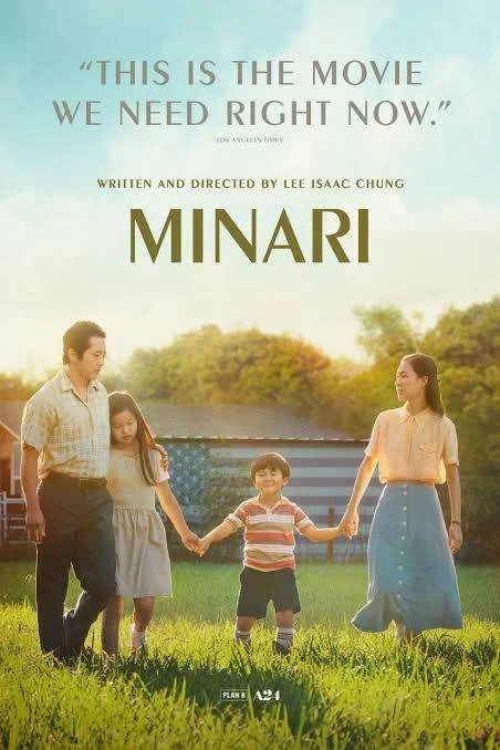 Poster for the movie 'Minari' showing a family of five holding hands in a grassy field with trees and sky in the background, and a quote about the movie at the top.