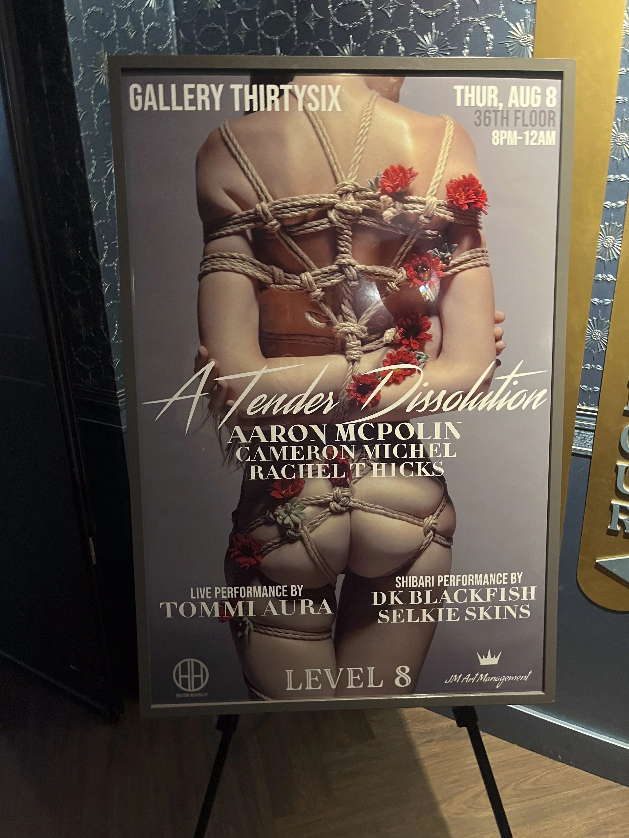 Poster advertising an event called 'A Tender Dissolution' at Gallery ThirtySix, scheduled for Thursday, August 8, on the 36th floor from 8 PM to 12 AM. The poster features an artistic photo of a person wrapped in ropes with red flowers. Performances 