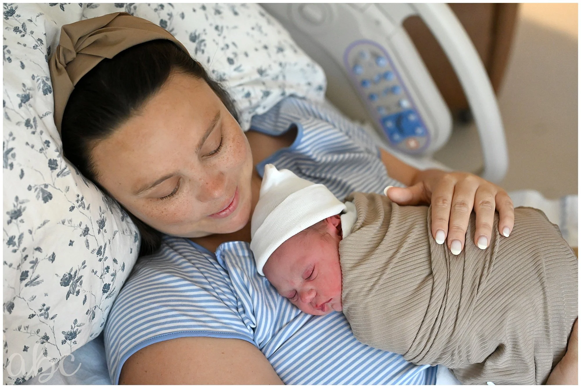 Mom cuddles in bed with her newborn after getting her VBAC