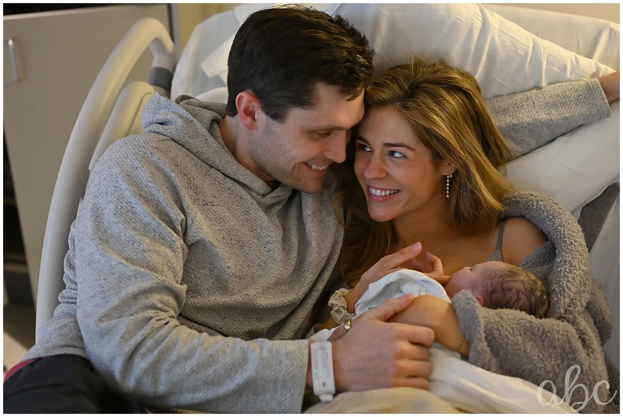 Couple joyfully cuddles their new baby in photo taken by atlanta birth photographer and north fulton hospital