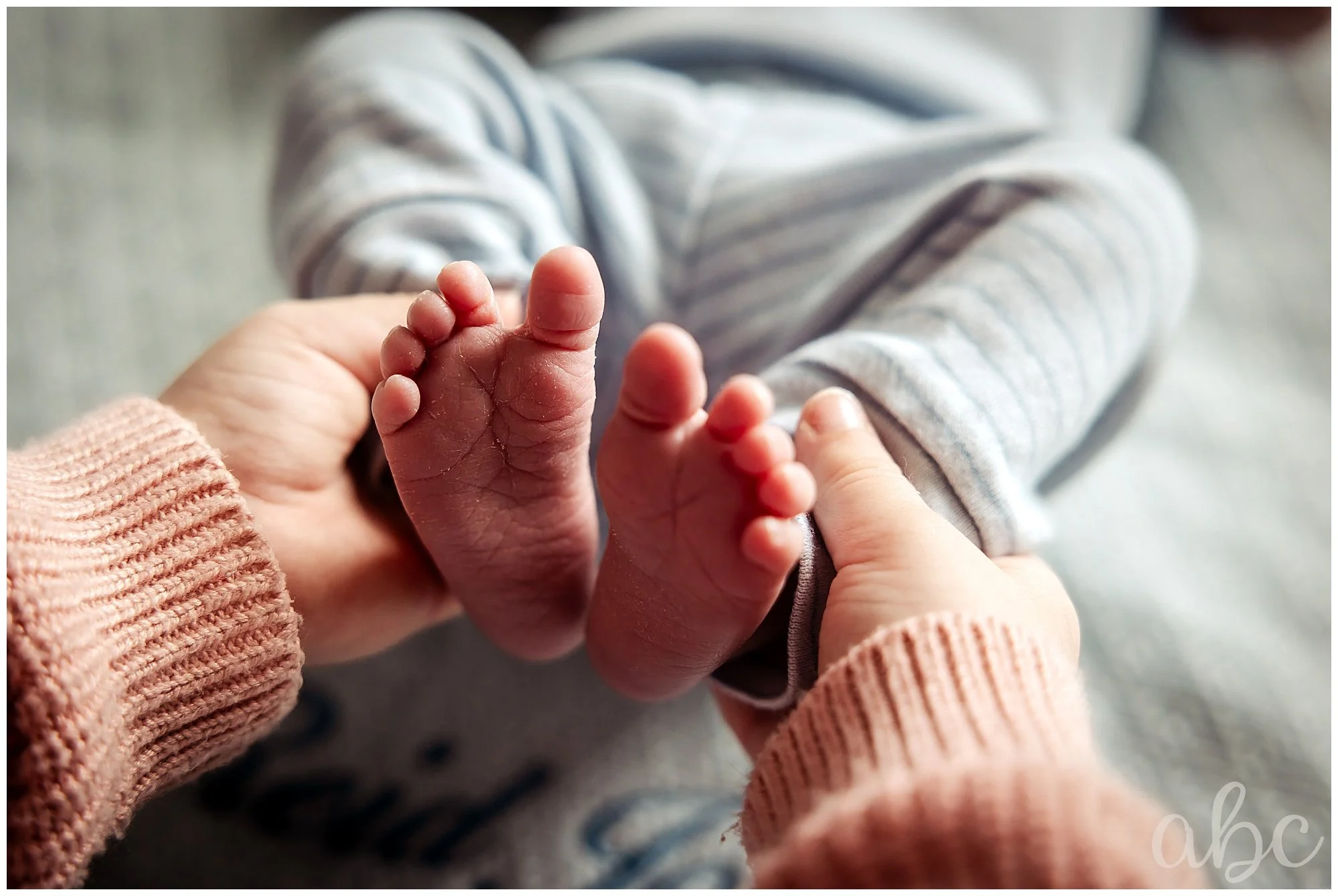 Baby feet being held by big sister