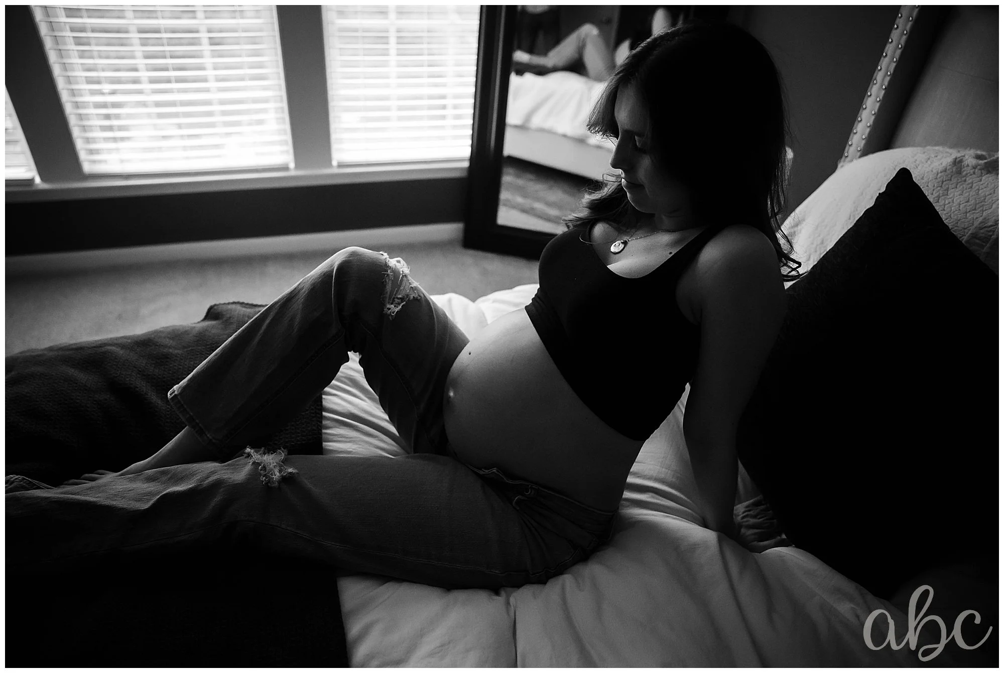 Mom leans back in bed while her Woodstock doula discussing birth