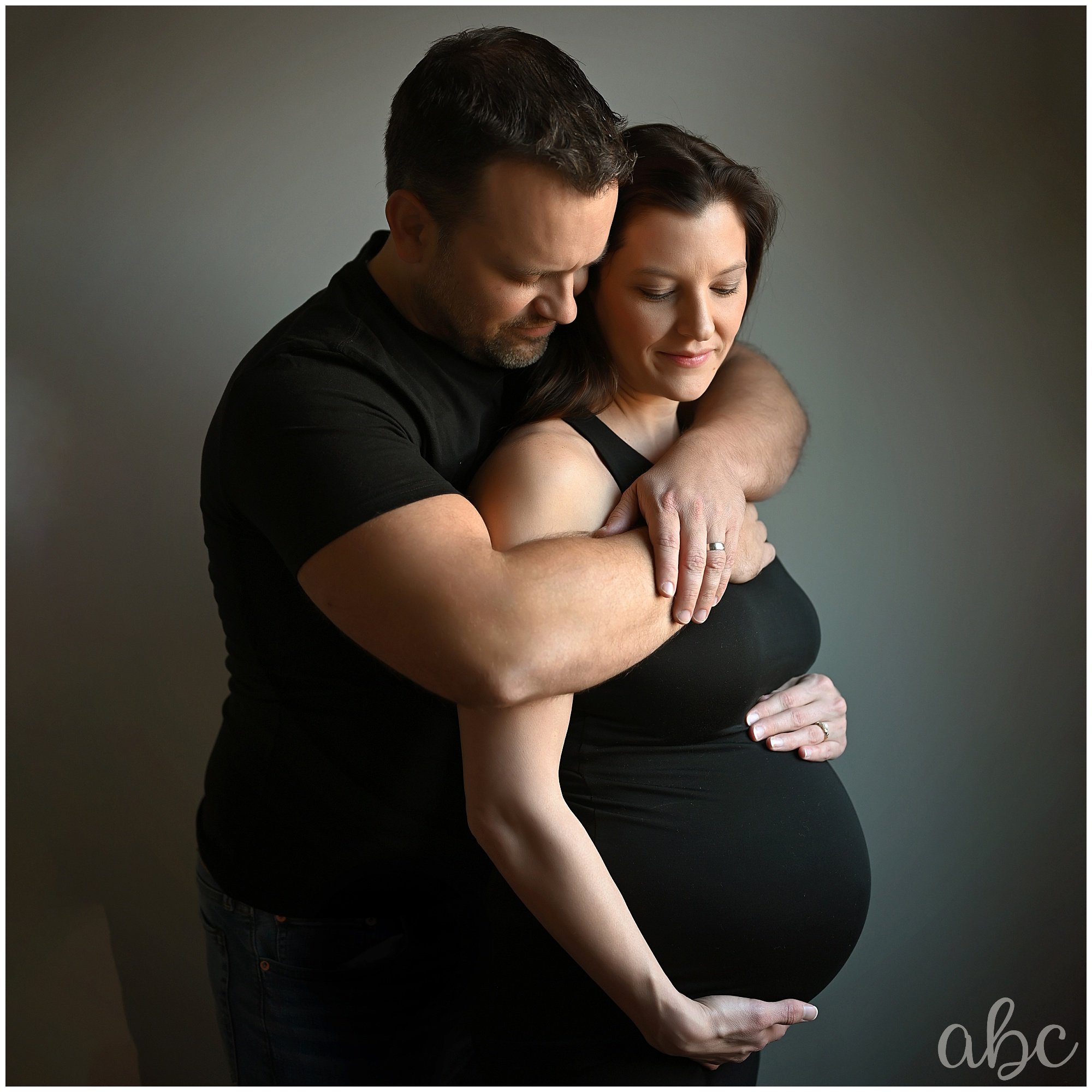 Couple cuddles while woodstock doula photographer poses them