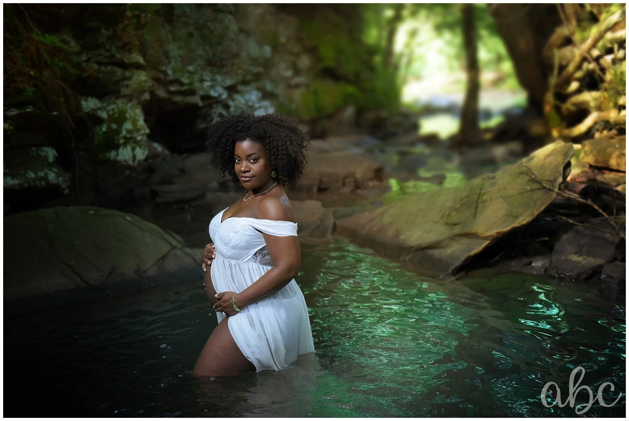 Roswell doula Maegan Hall poses mom in a creek in Marietta, ga