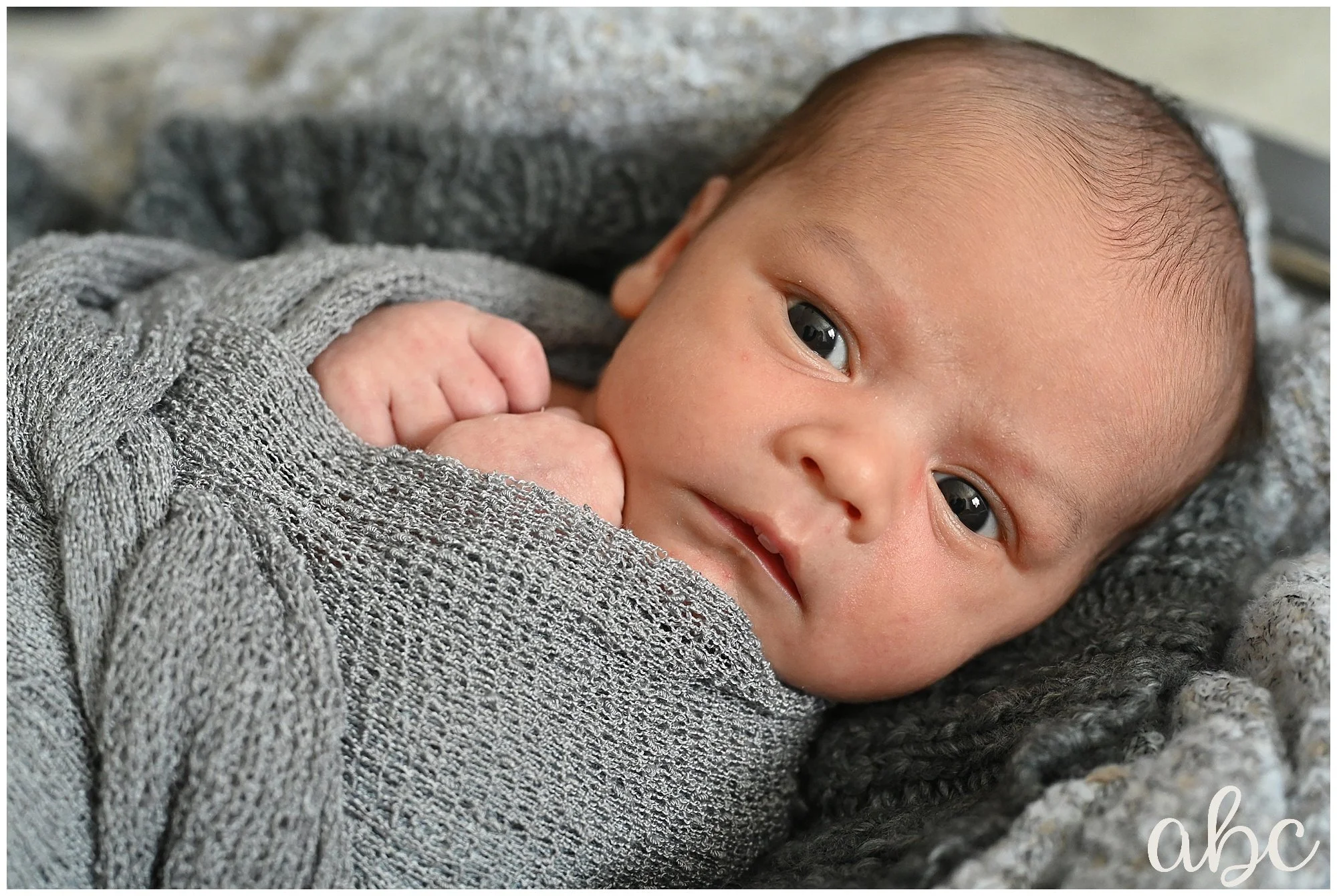Newborn baby is swaddled for his newborn photoshoot with Roswell Doula Photographer