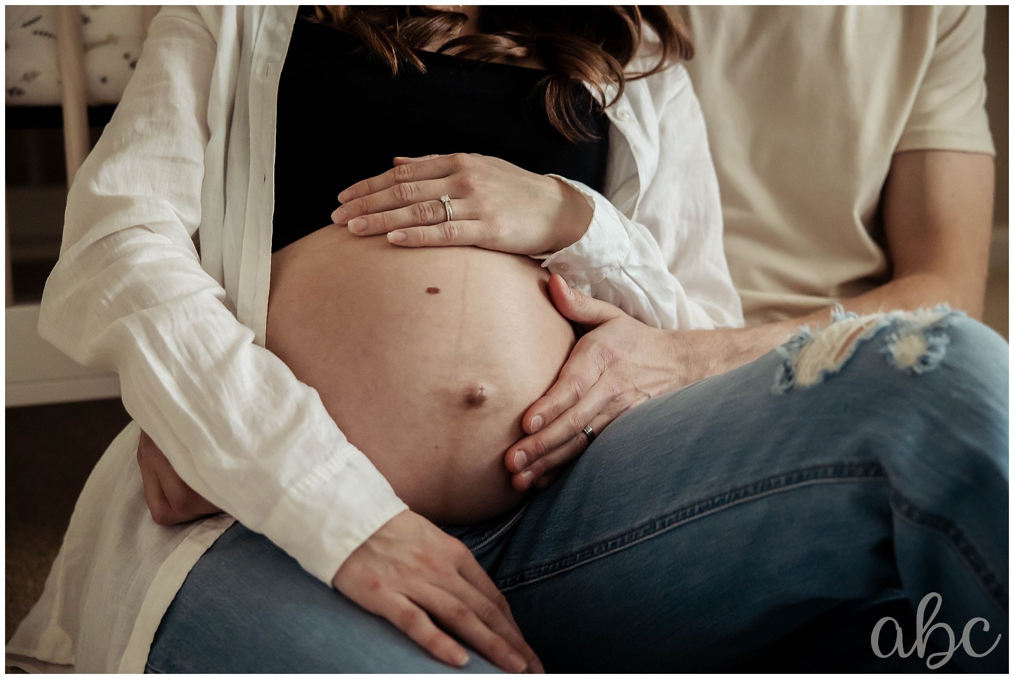 Couple sits in the nursery and cuddles.