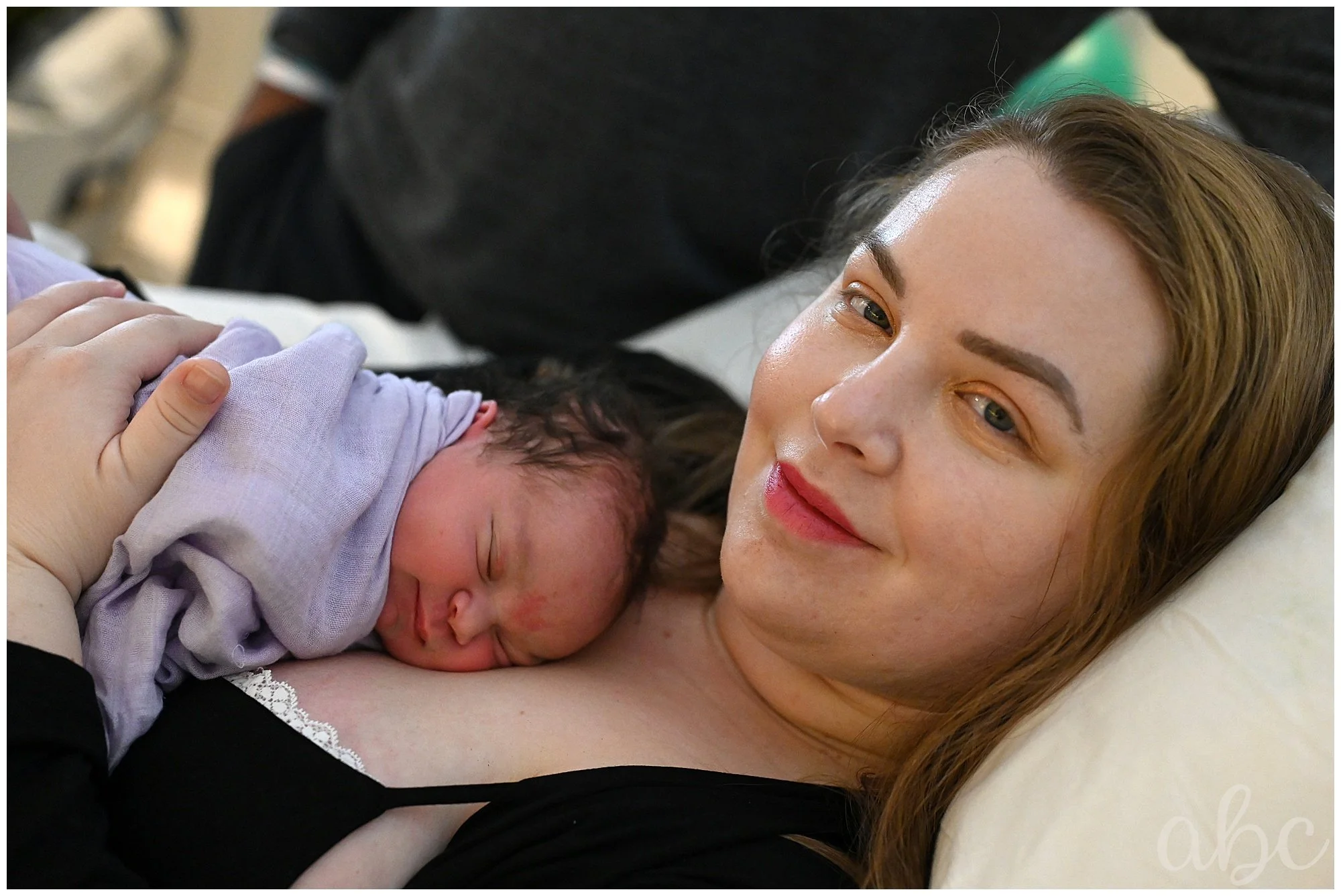 Postpartum mom cuddles her newborn in the hospital with Atlanta Doula