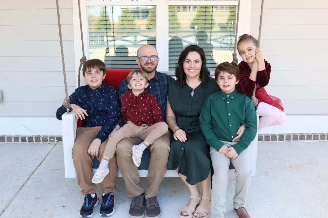 Woodstock Postpartum doula photographer MIlene poses for a photo with her family