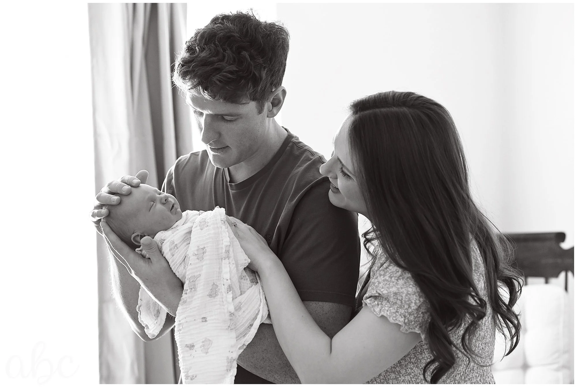 Doula photographer in woodstock poses family to look at their new baby