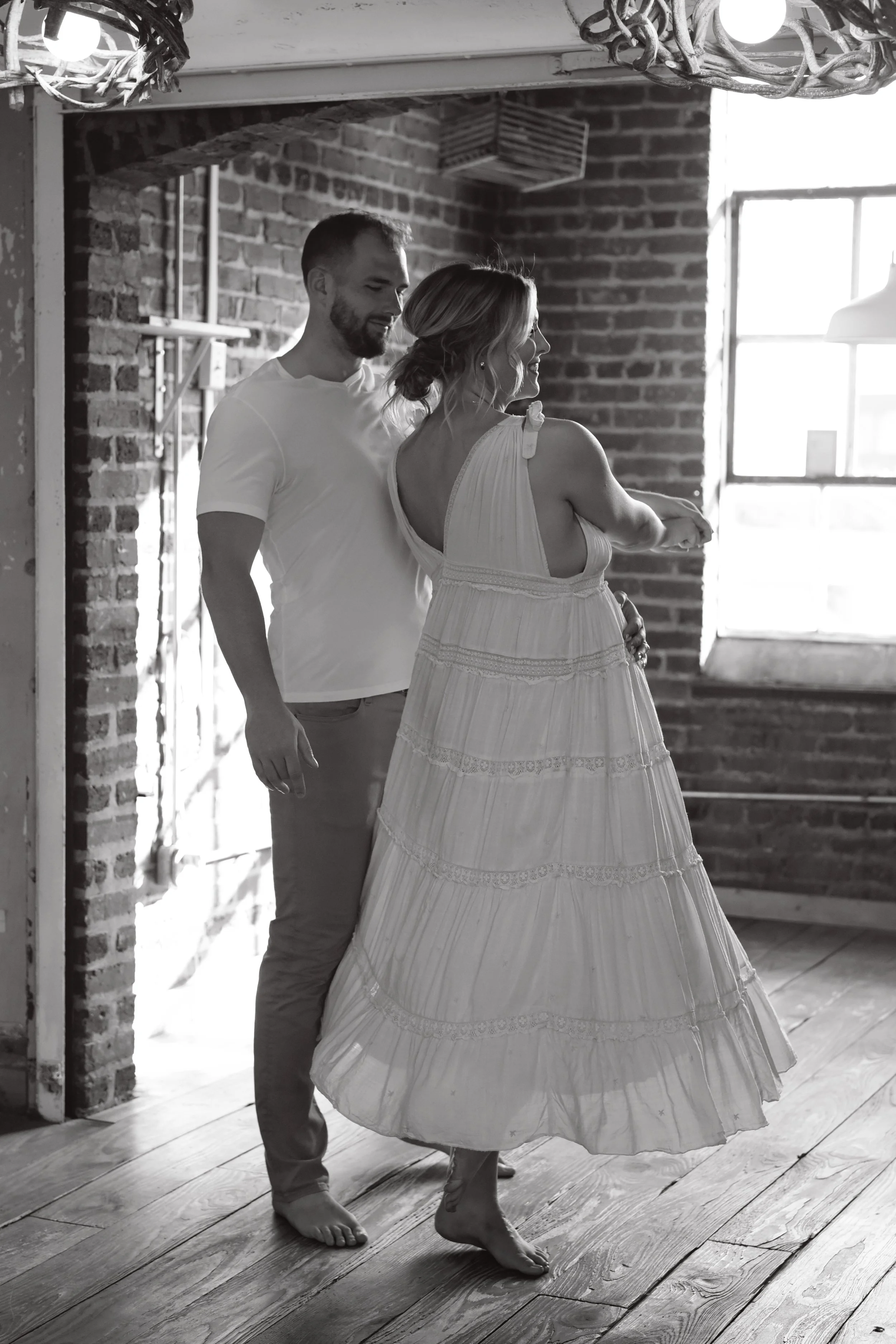 Roswell doula photographer photographs a black and white photo of a man and woman, with the woman pregnant, dancing together.