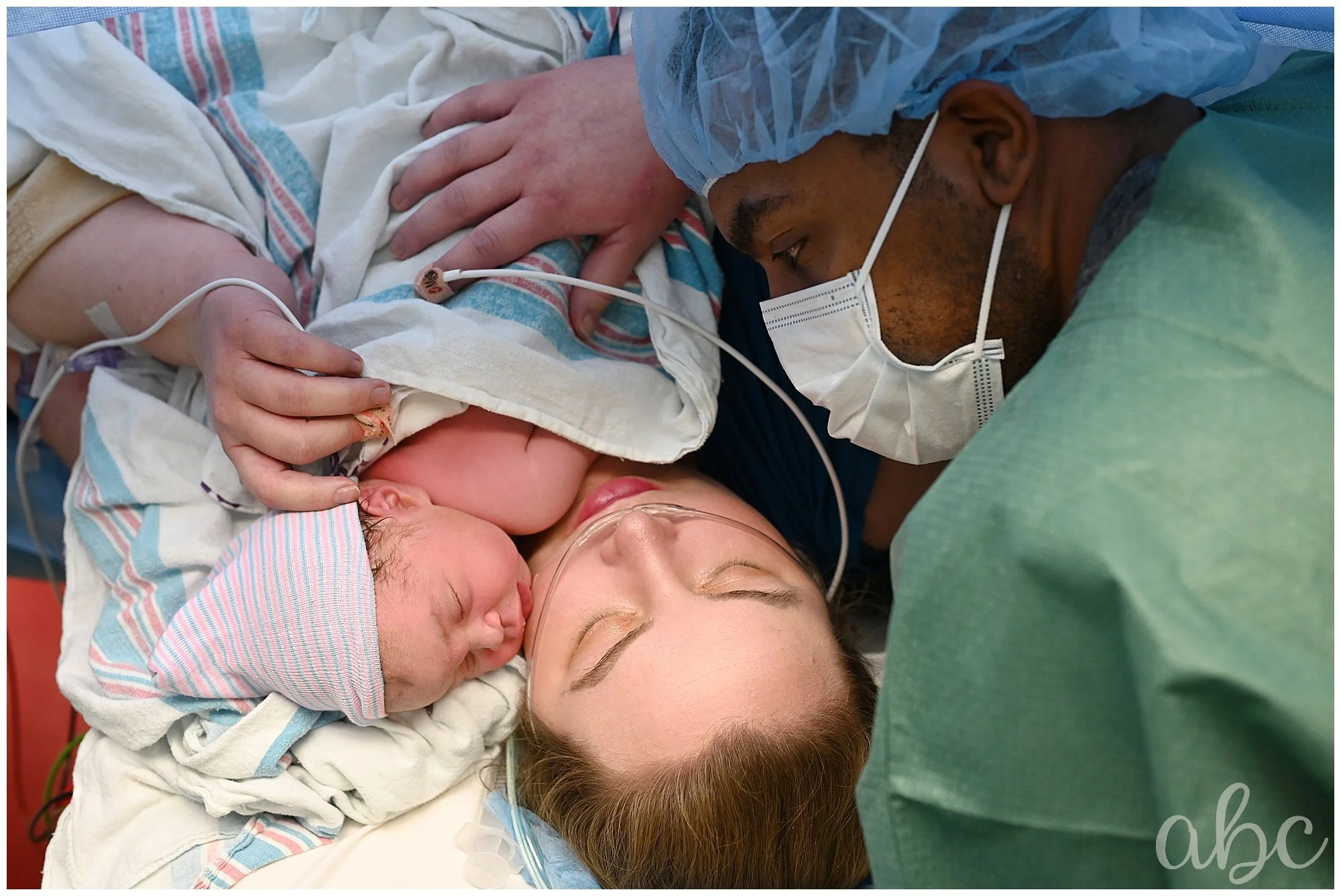 Parents cuddle their new baby in the OR while doula photographer captures skin-to-skin