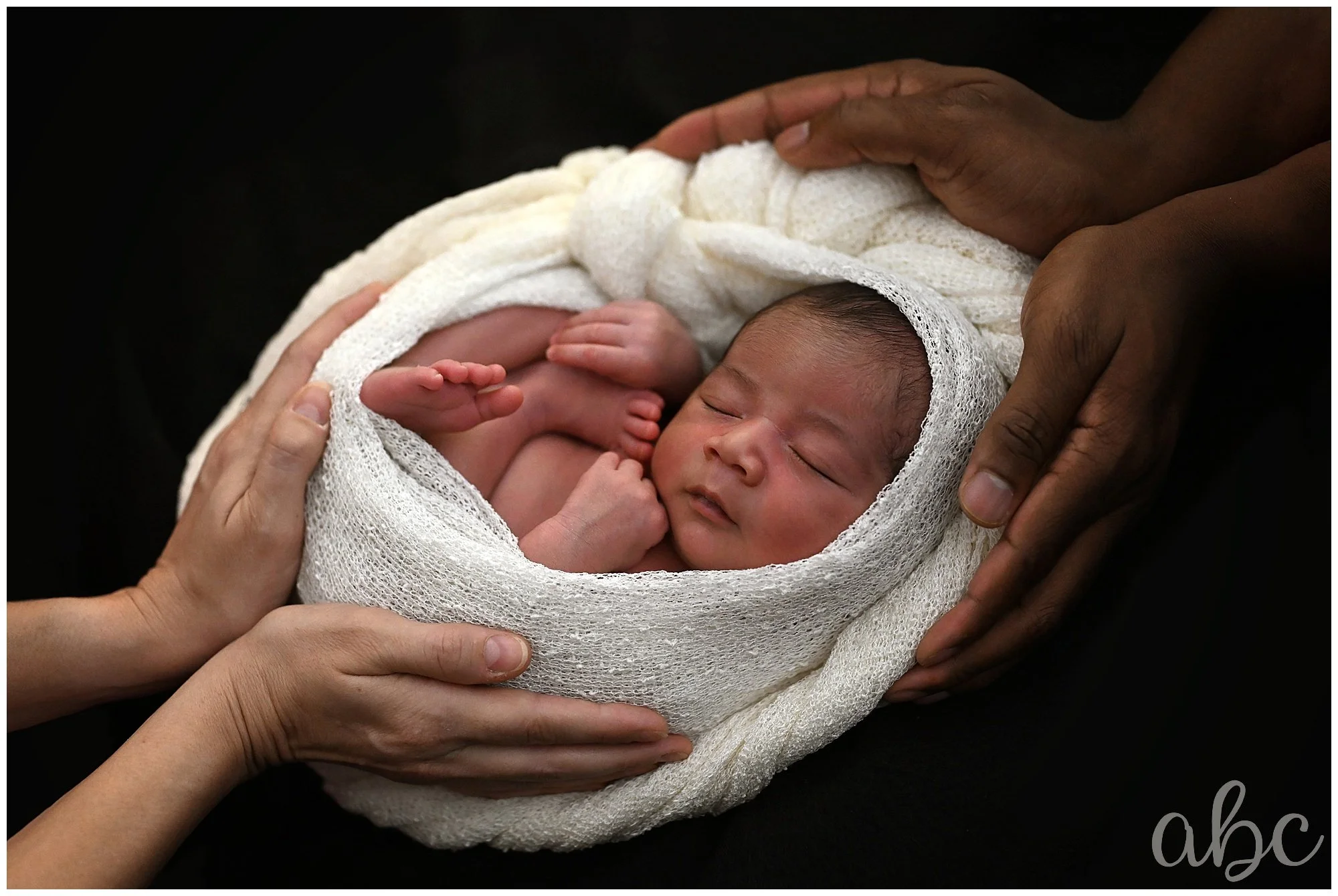 Mom and Dad cradle baby at newborn photoshoot with Woodstock Doula Photographer