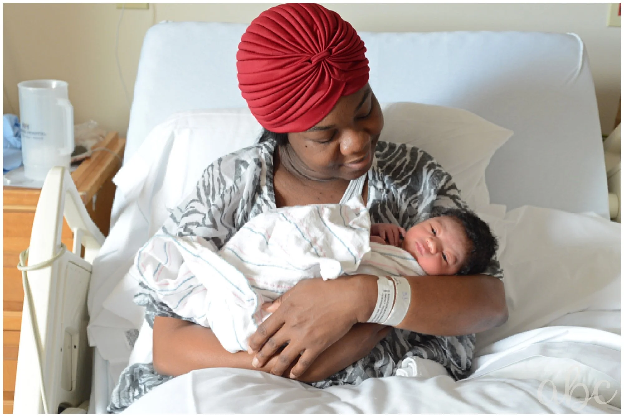 Baby and mom cuddle in hospital bed with Doula Maegan Hall