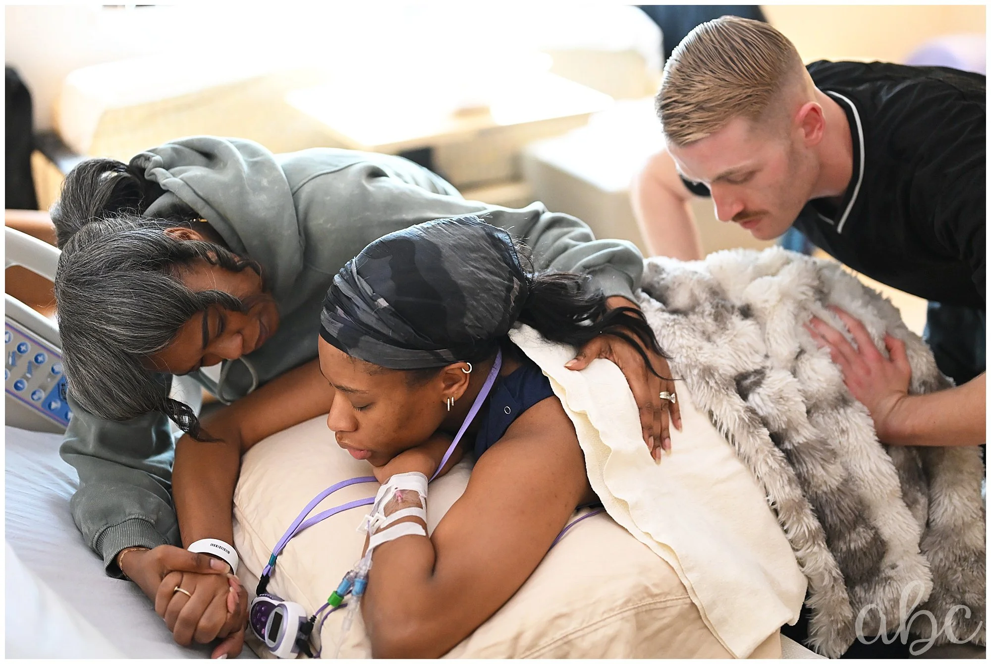 A grandmother is offering support to the laboring mom while Roswell Doula photographer takes photos