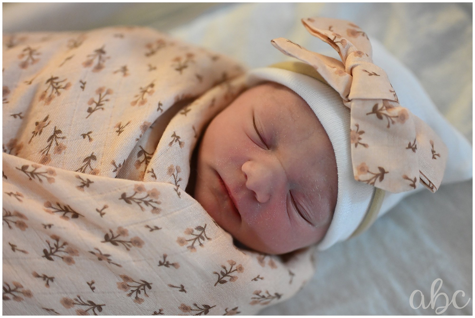 New baby is swaddled in a pink blanket while atlanta doula photographer takes photos
