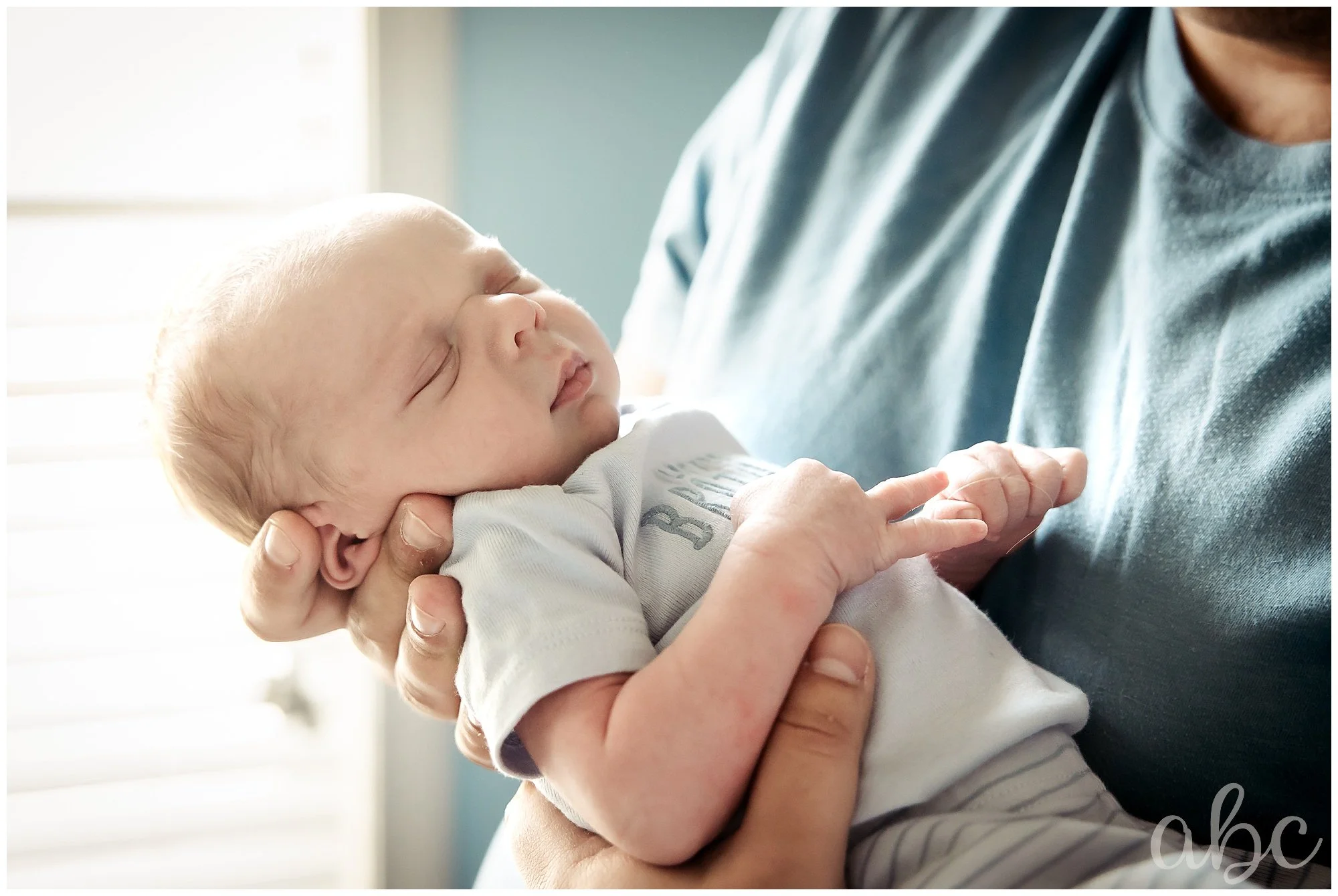 Dad holds newborn baby boy at photo shoot