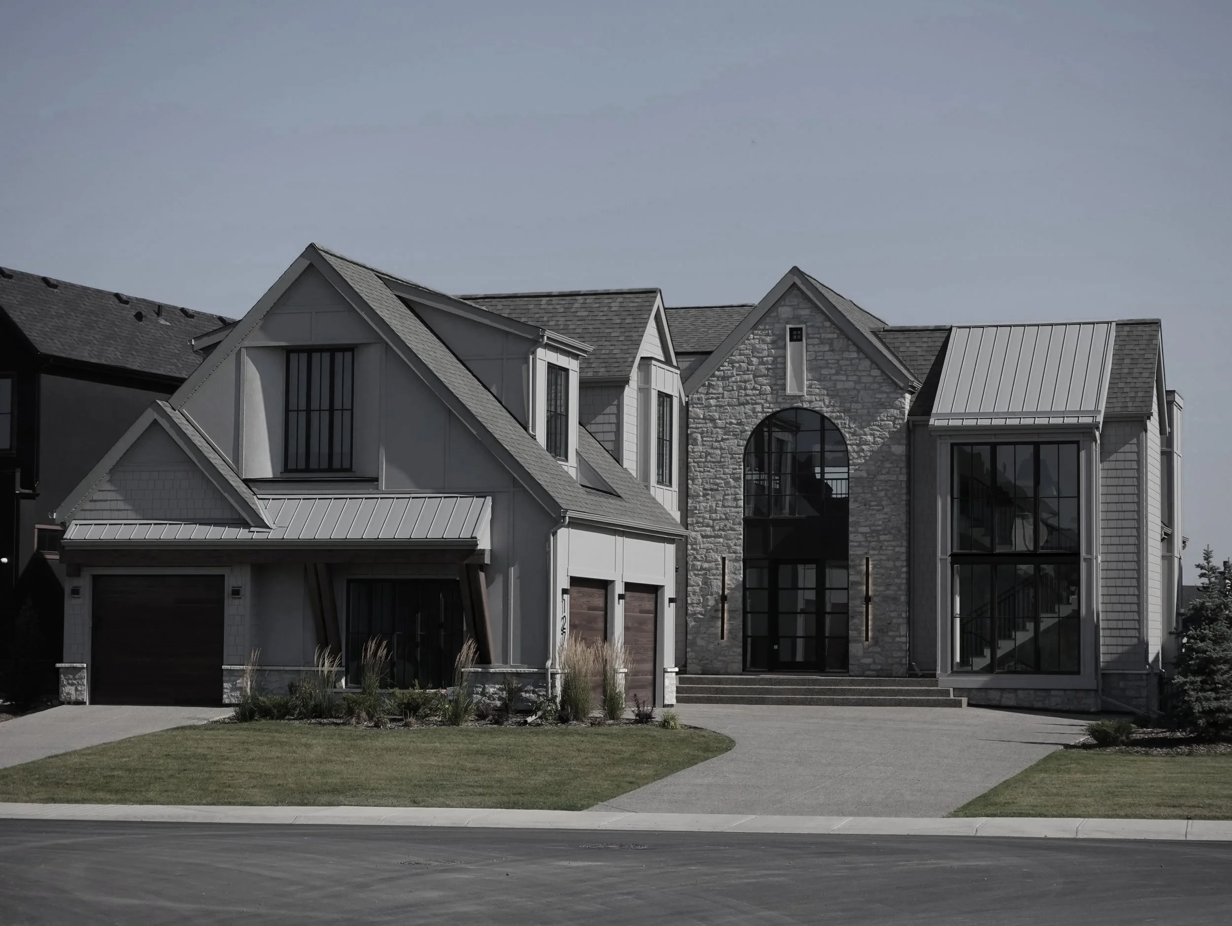 Traditional style Watermark at Bearspaw showhome backing onto the pond, featuring classic architectural detailing — designed by THAD.