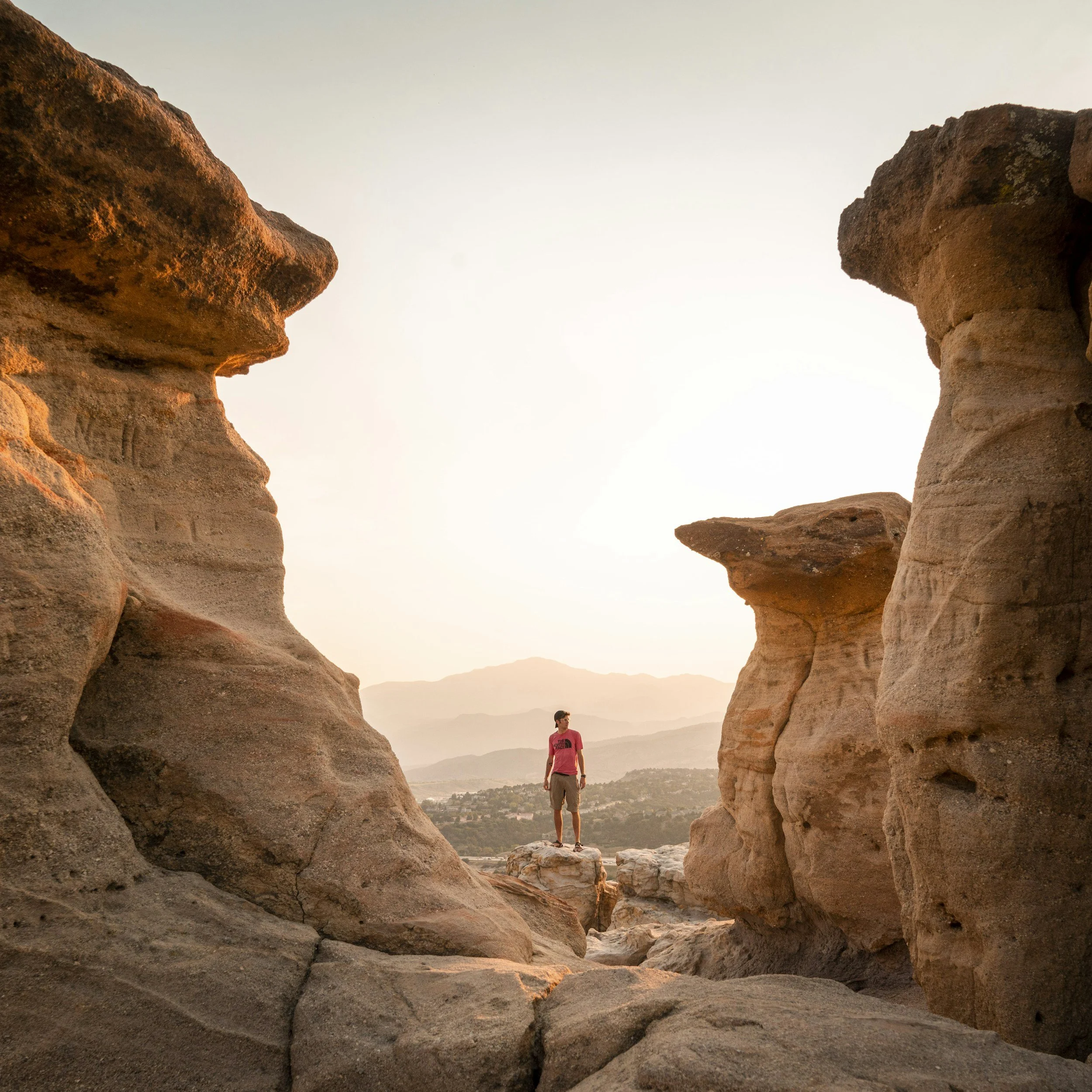 Serene mountain backdrop of Pikes Peak with a person hiking or meditating, soft sunlight