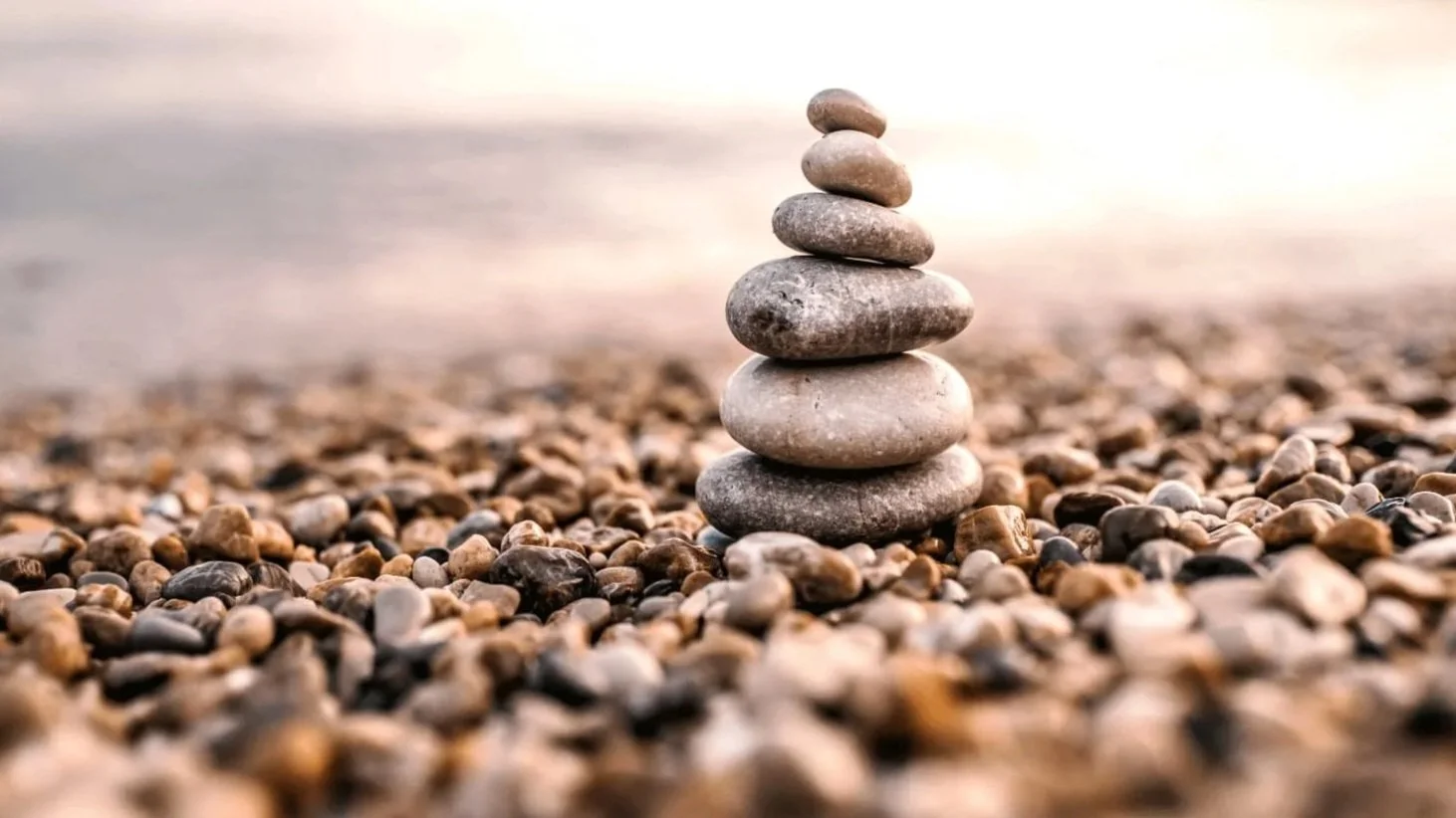 A stack of smooth, rounded stones balanced on top of each other on a pebble-covered beach in Minnesota.