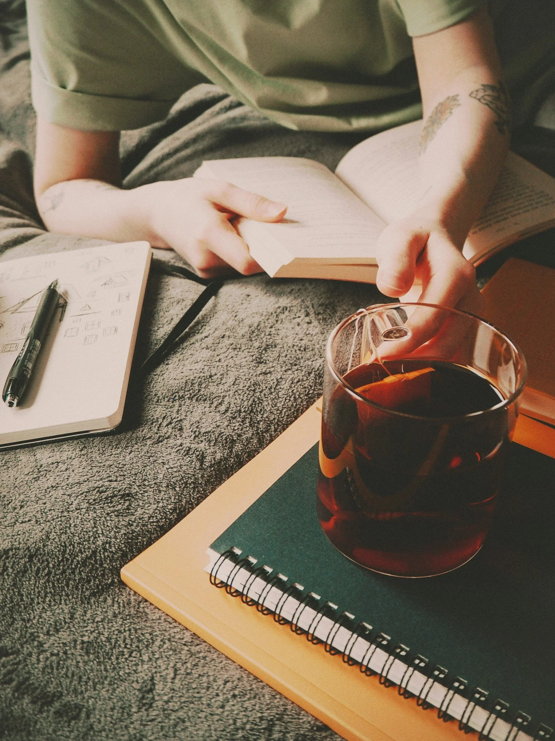Warm-toned photograph of hands holding a mug of tea, symbolizing reflection, refinement, and grounding during the luteal phase.