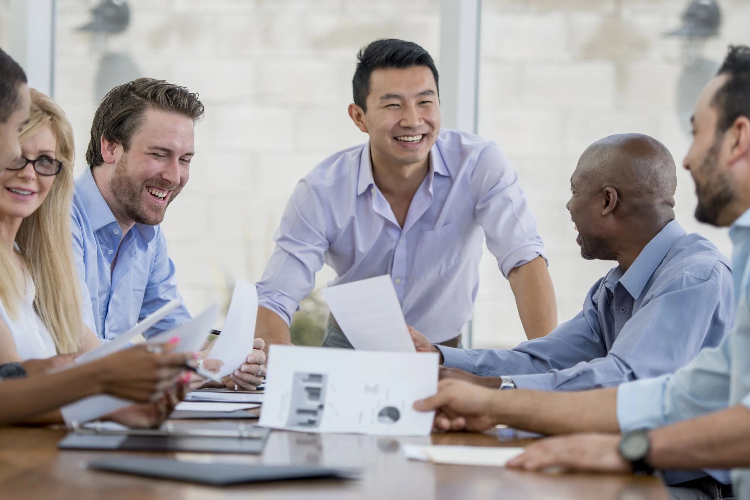 Two men with big smiles on their faces connecting during a work presentation