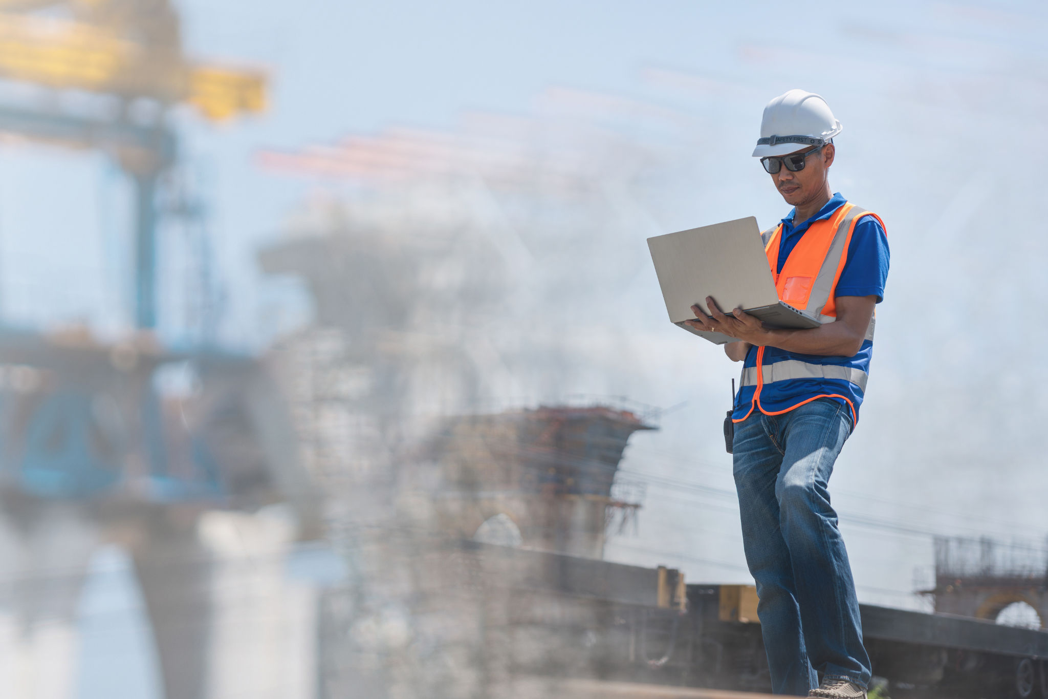 Contractor on laptop representing construction bookkeeping pricing based on job volume, complexity, and accurate job costing systems.