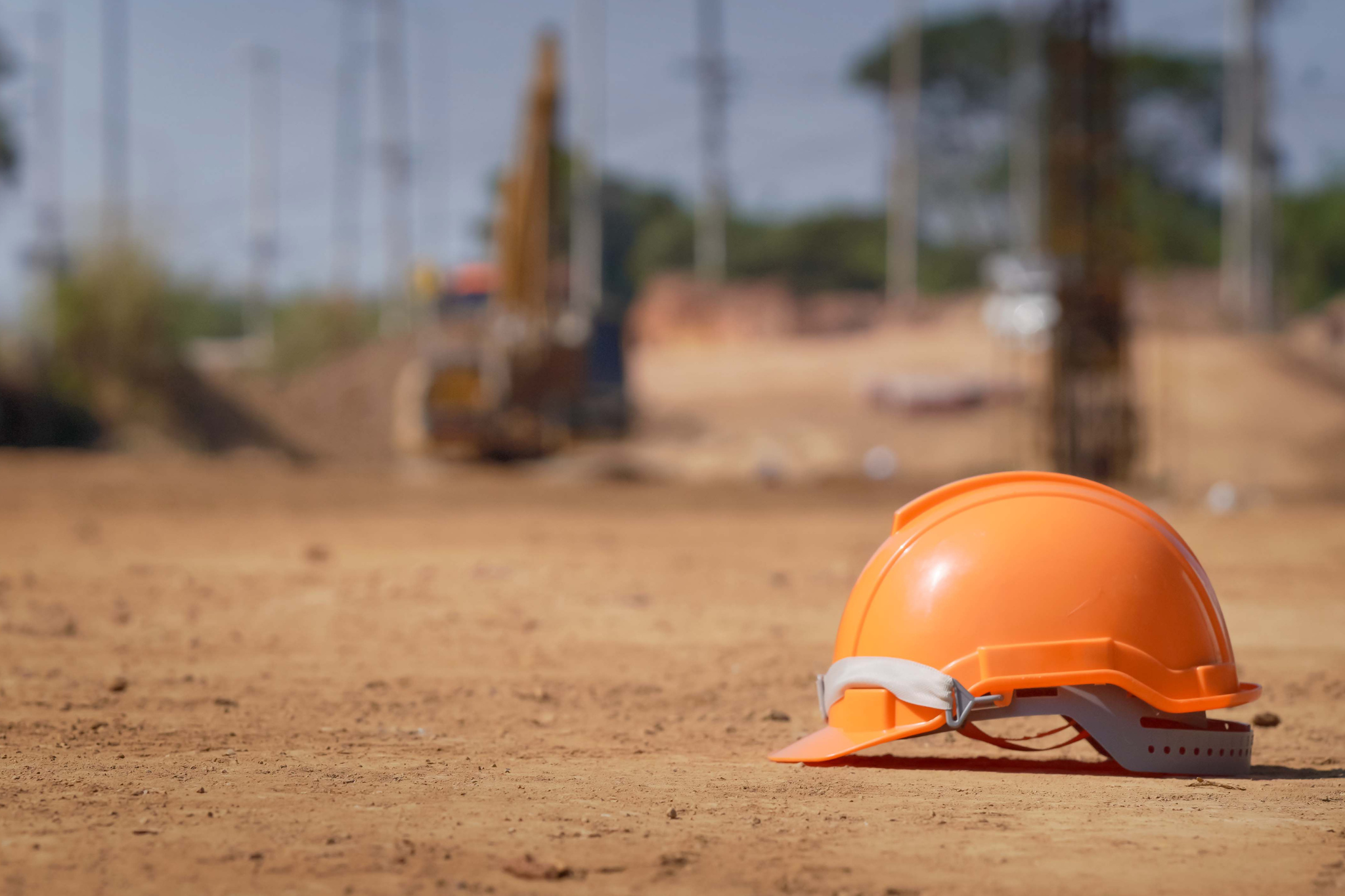 Construction hard hat on an active job site illustrating how larger construction projects can create payroll strain, billing delays, and cash flow challenges for growing contractors.