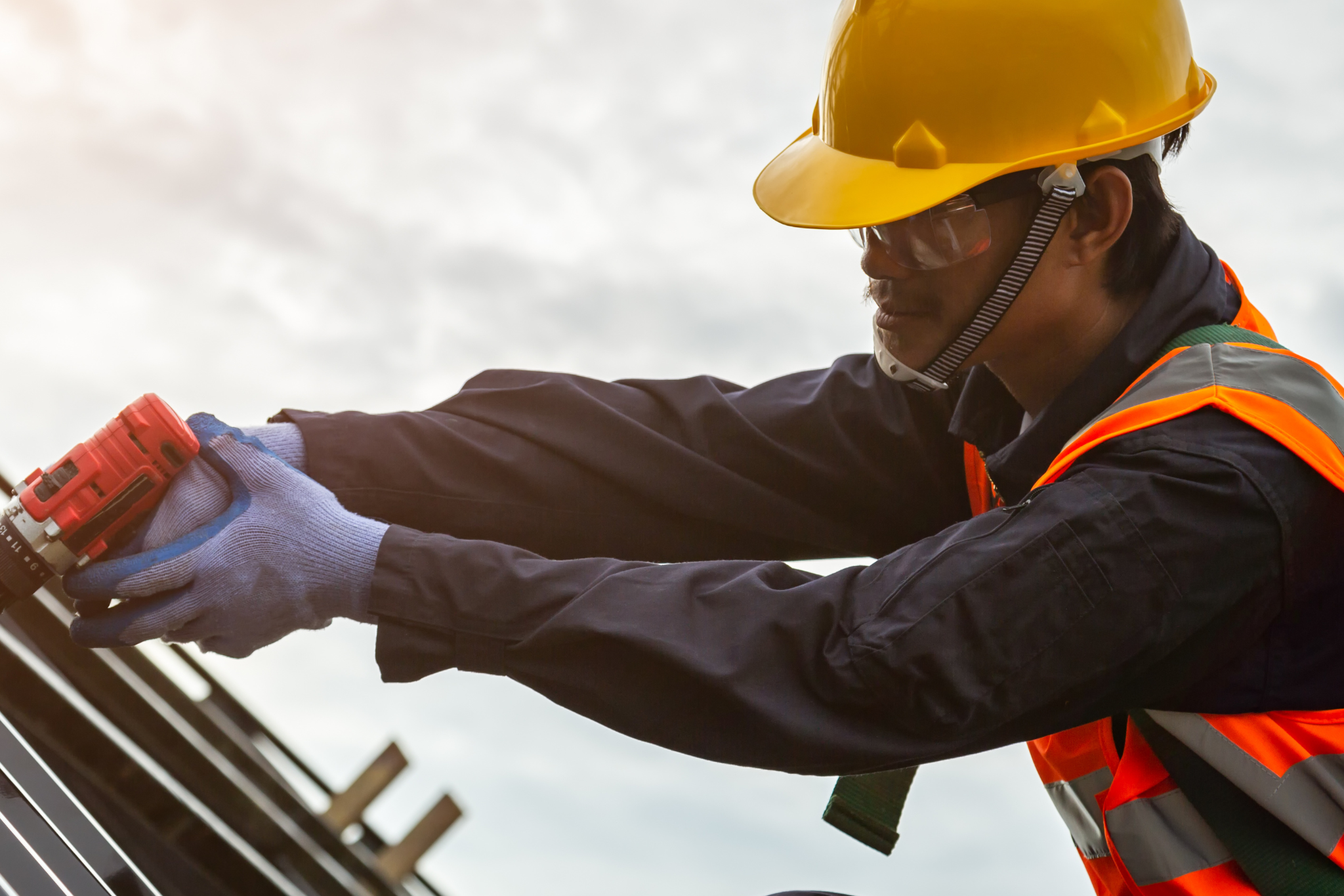Construction worker reviewing project plans on an active job site, representing how weak construction systems can lead to reporting issues, delayed billing, reduced job visibility, and hidden profit problems for contractors.
