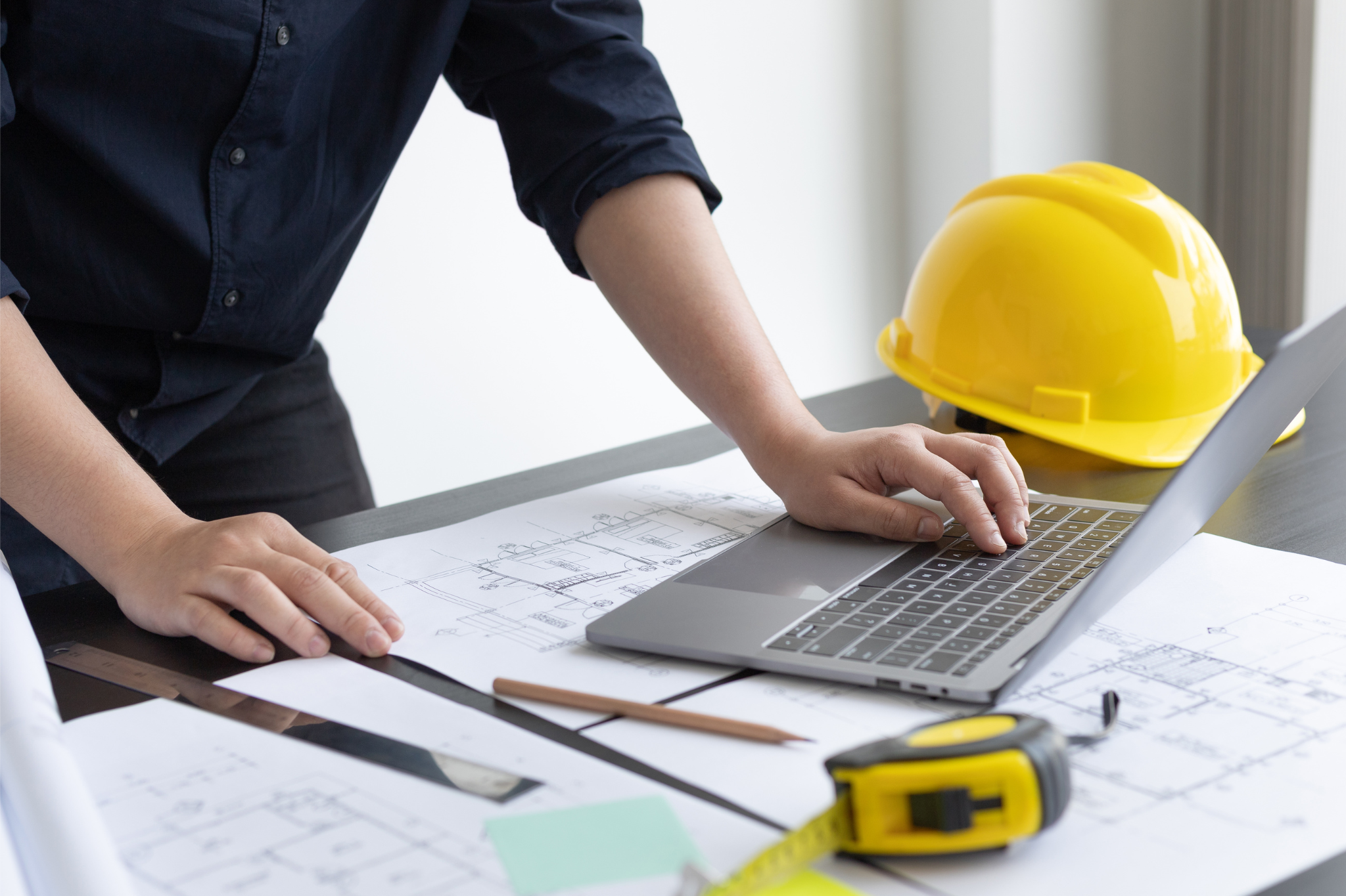 Contractor using laptop for construction budgeting and cost code tracking