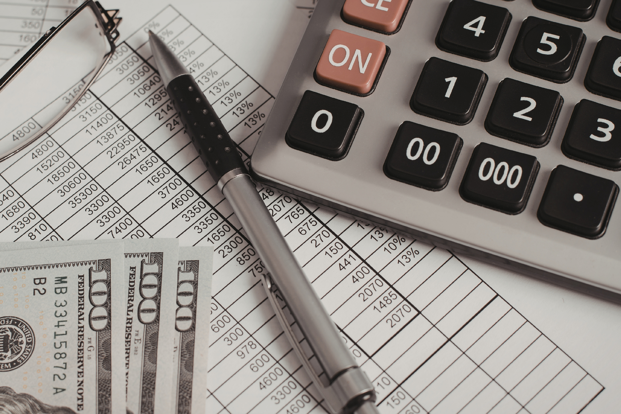 Calculator and financial sheet representing construction financial controls that keep job costing, billing, payroll, and reporting accurate and prevent profit leaks.
