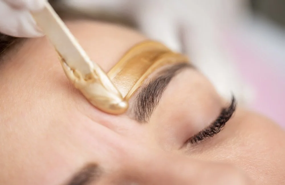 A woman receiving an eyebrow wax.