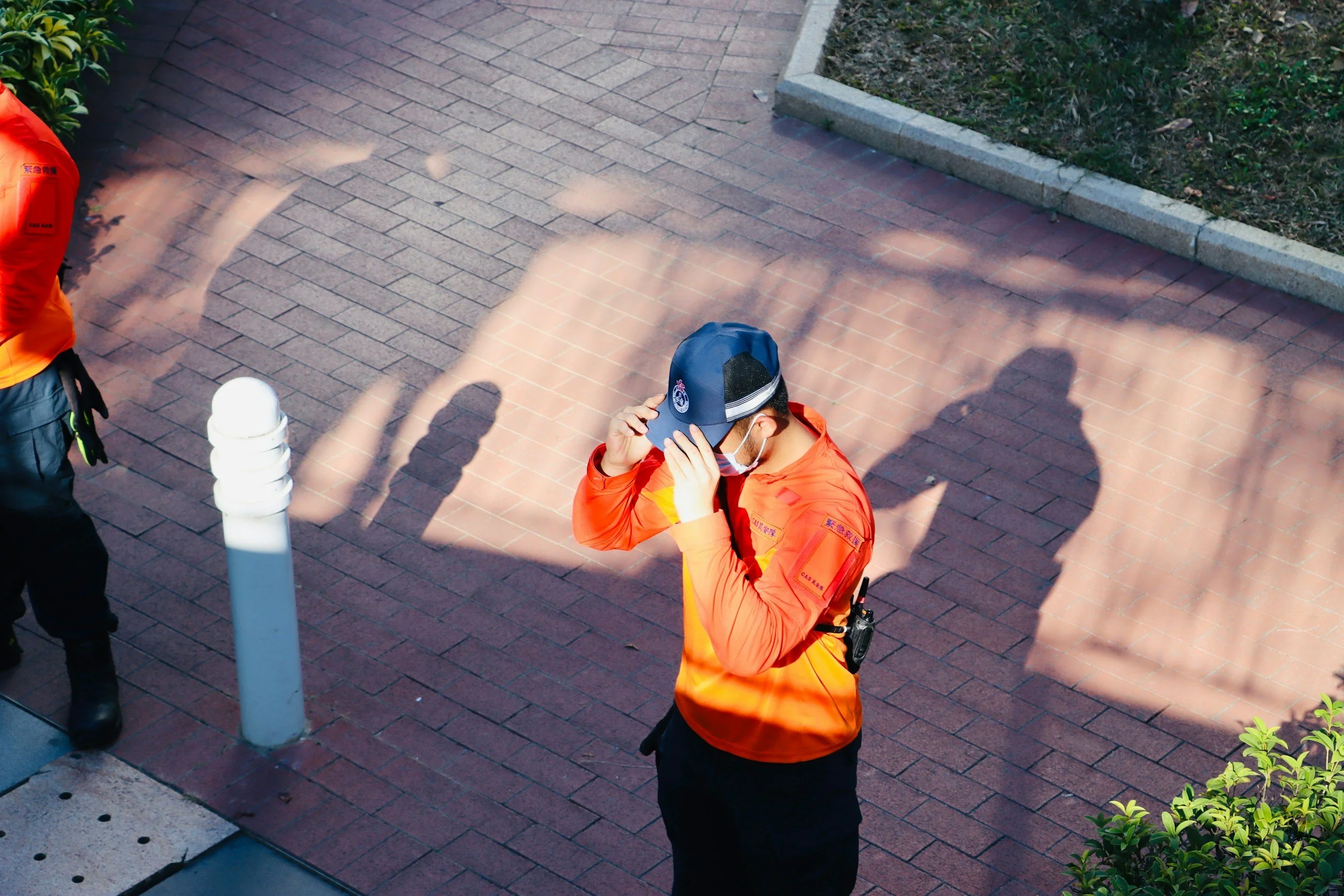 First responder holding hat, with shadow behind. Anxiety