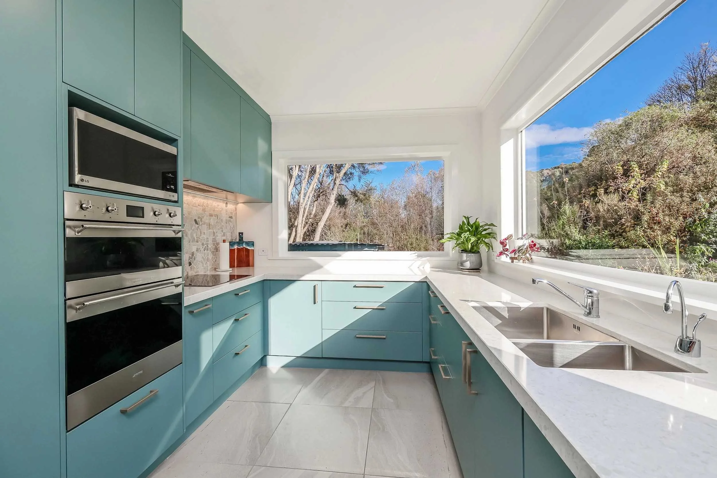 Bright modern kitchen with natural light in a Dunedin home, photographed for a real estate listing.