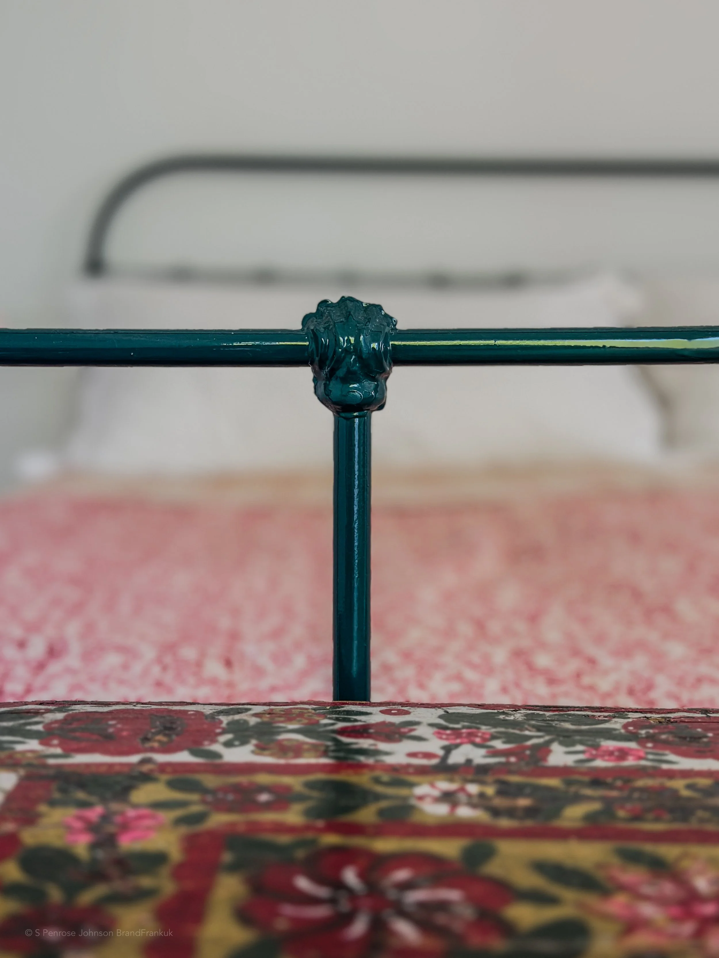 Close-up of a blue metal antique bed frame and cosy cocomat bed at The Selene Greece in Nimborio, Symi.
