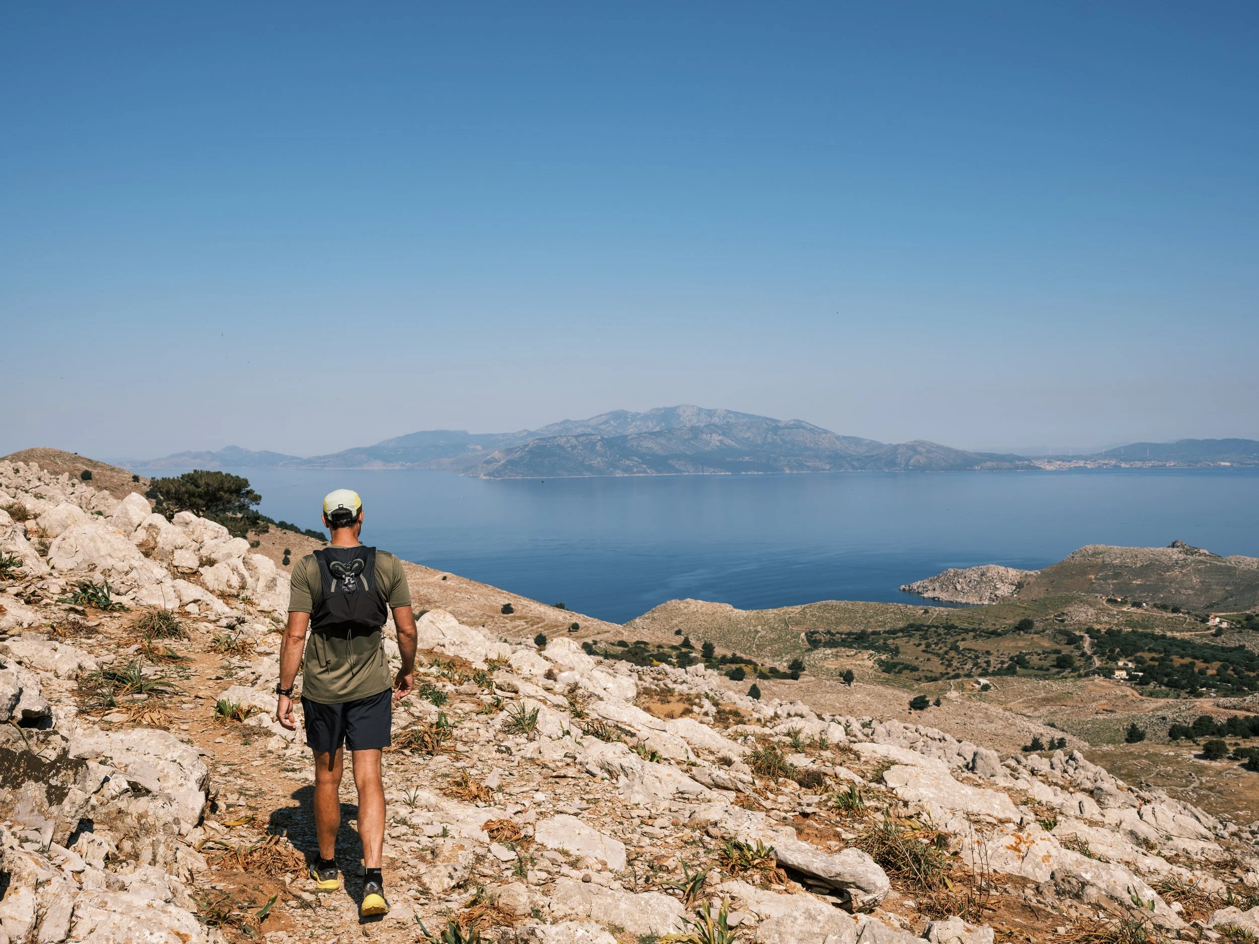 hike across mountain top with views of turkey in the distance. the selene greece symi