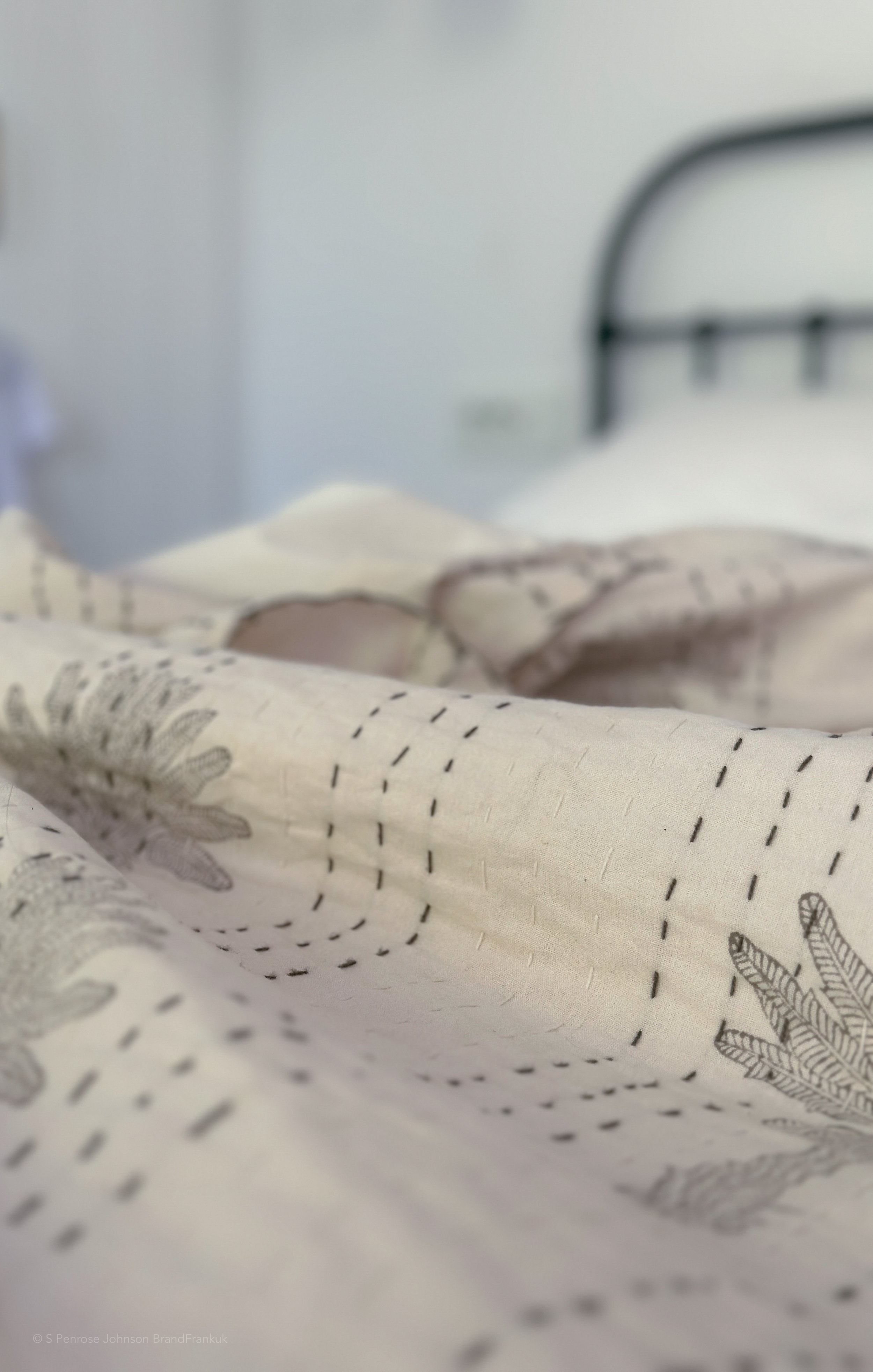 Close-up of linen bedding and antique iron bed in Nykta room at The Selene Greece in Symi.