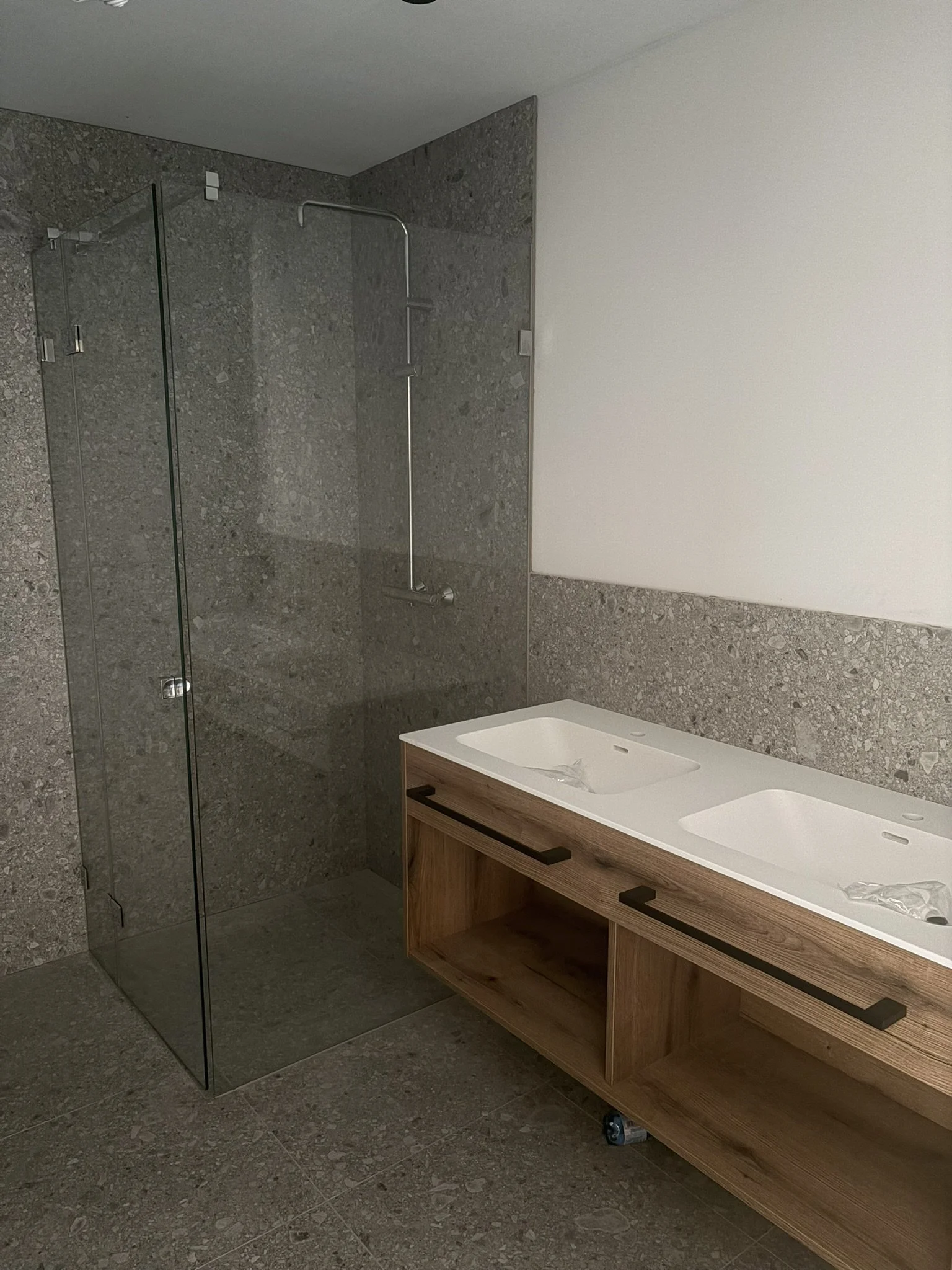 Badezimmer mit Doppelwaschtisch und begehbarer Glasdusche