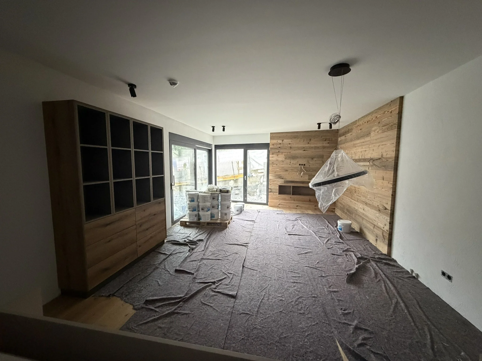 Wohnraum mit Altholzverkleidung und Einbaumöbeln im Ausbau