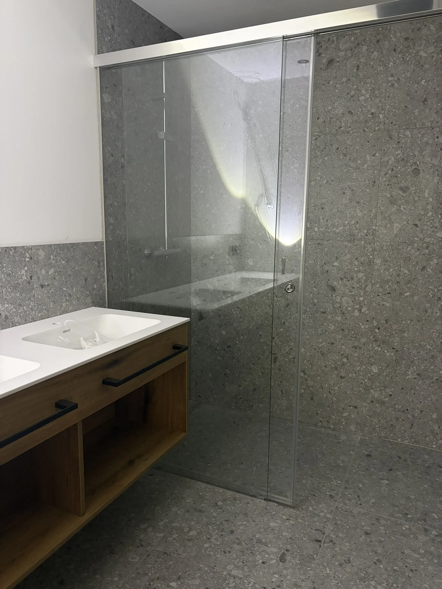 Badezimmer der homelodge Ladis mit Glasdusche und Steinoptik-Fliesen