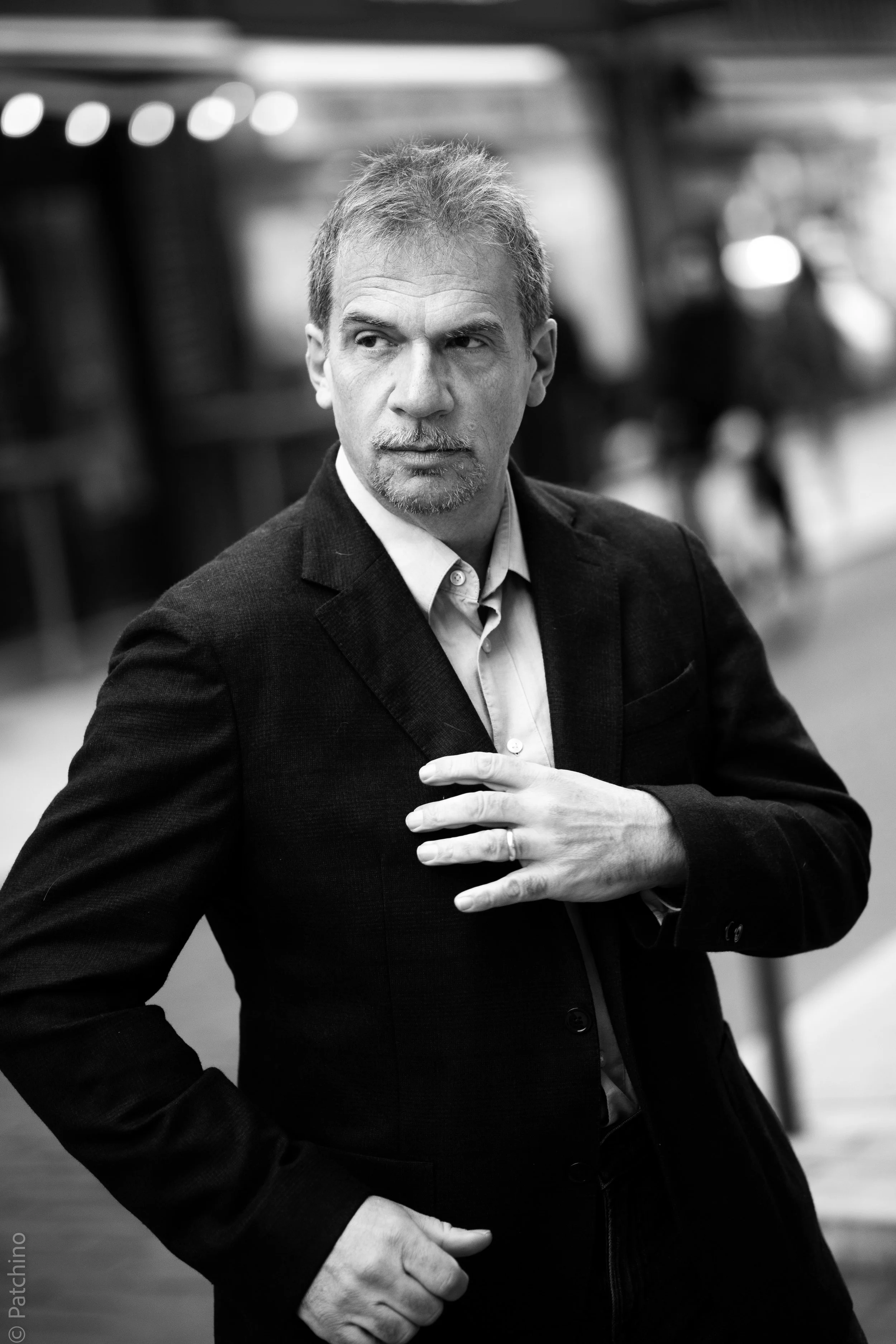 Pierre Diot, en costume, dans un environnement urbain, en noir et blanc.