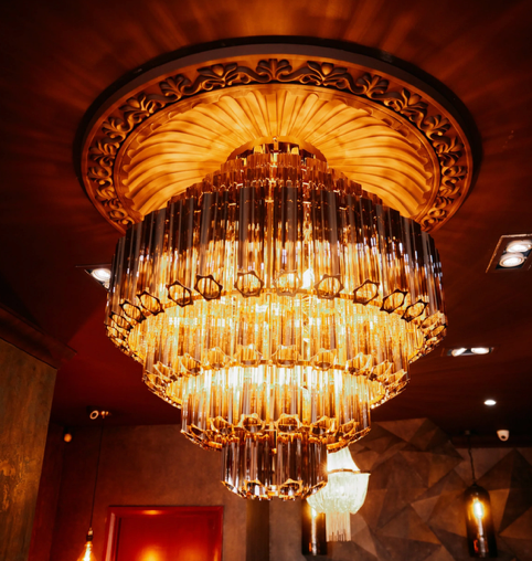 Luxurious chandelier with cascading glass or crystal tubes hanging from a decorative ceiling fixture.