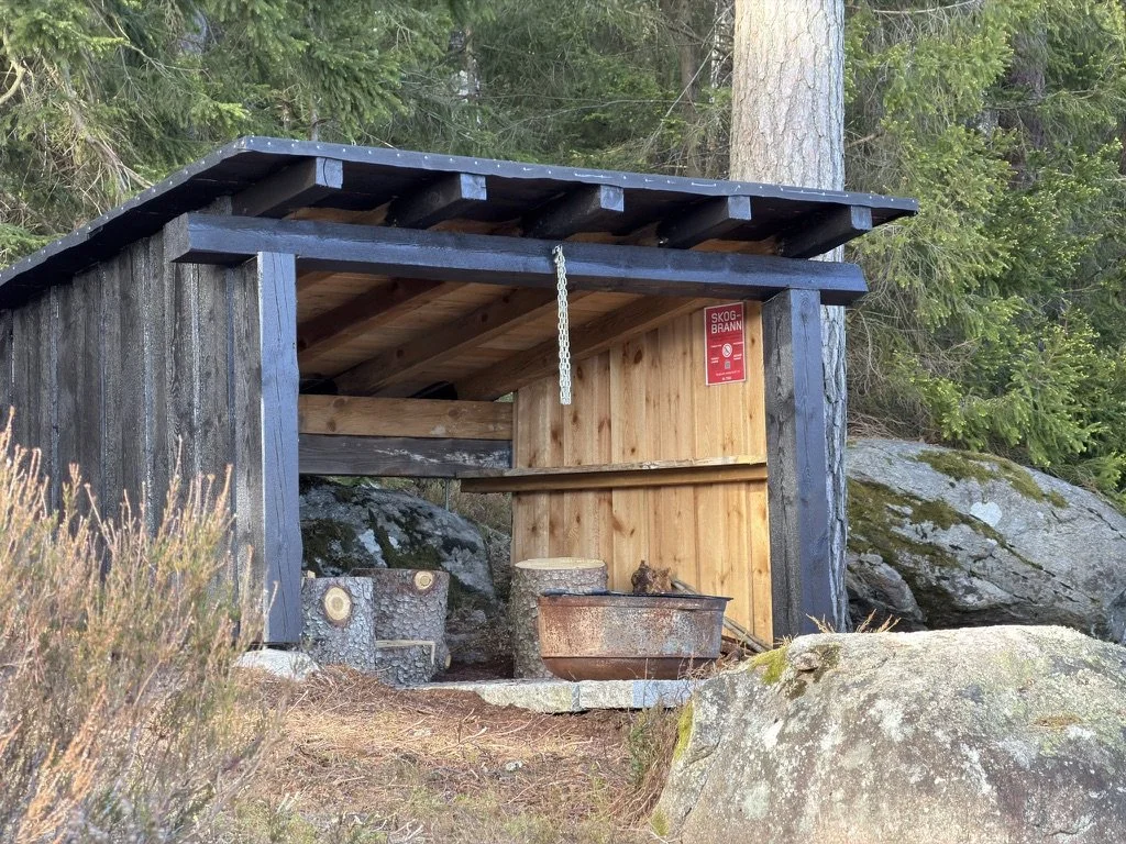 Gapahuk med bålpass og stubbestoler