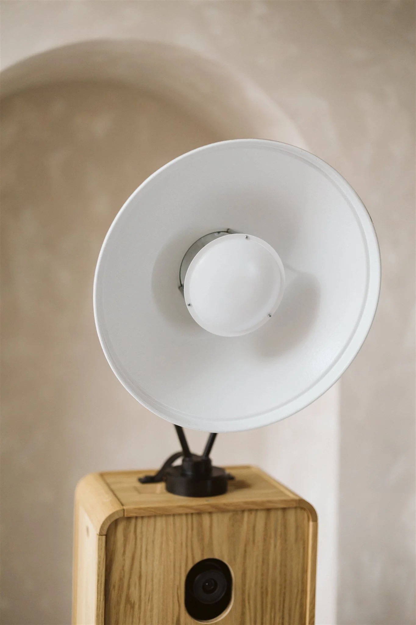 A modern wooden luxury photo booth with emphasis on the studio lighting mounted on top.