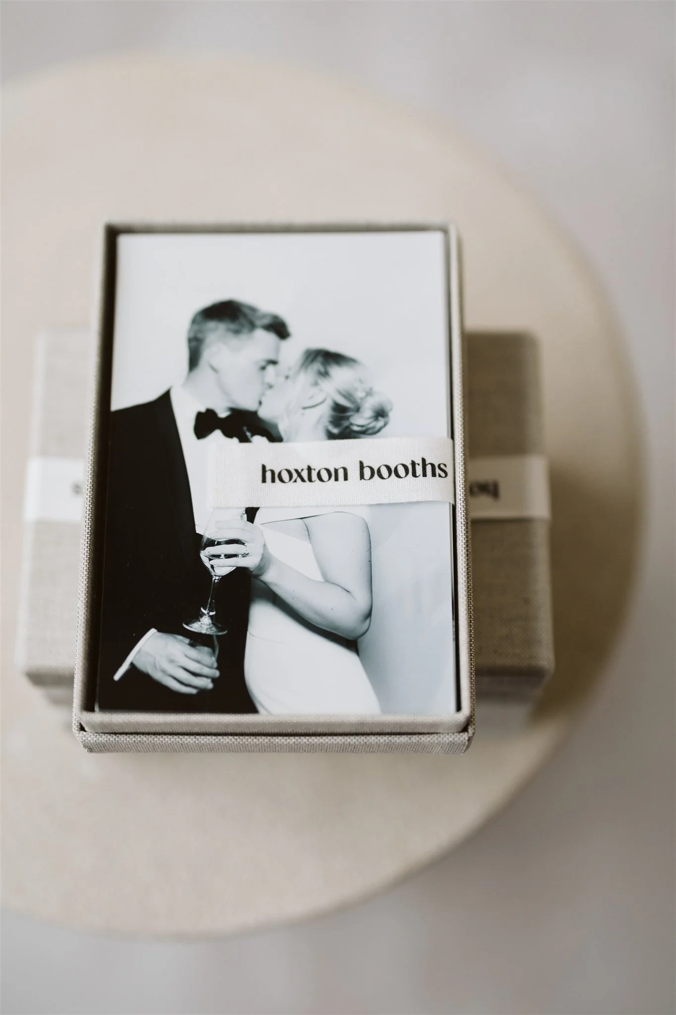 Packaging box featuring a black-and-white photo of a man and woman with drinks, with a label reading 'hoxton booths'.