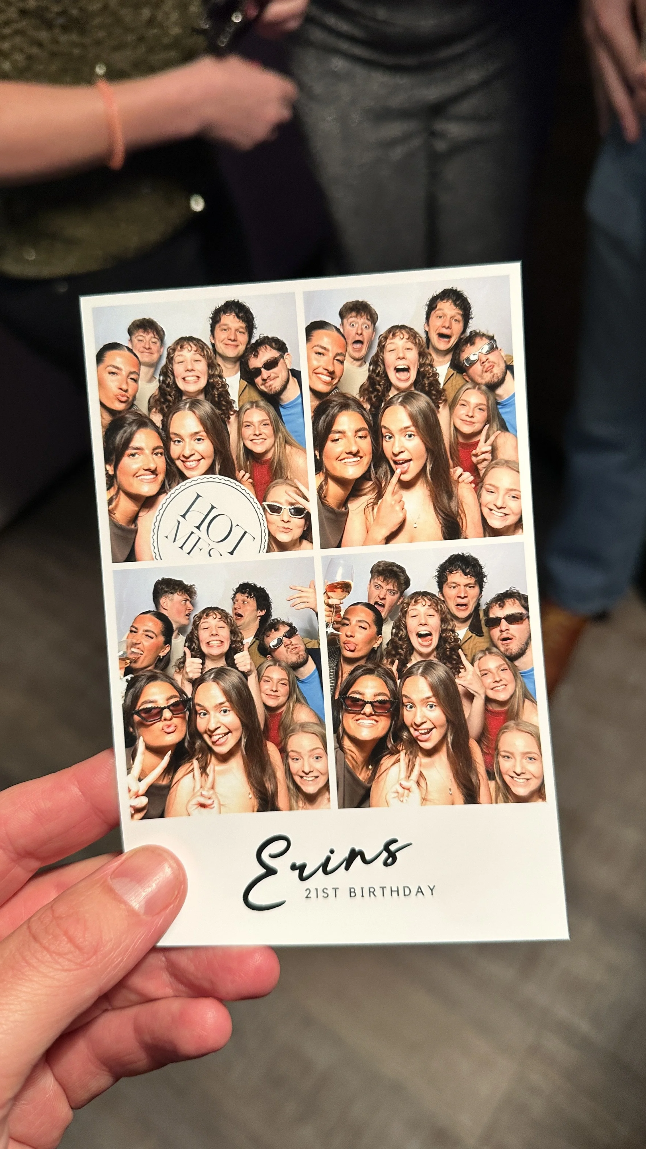 Photo booth strip with four images of a group of friends at Erin's 21st birthday celebration, smiling and making funny faces, with a mix of men and women in casual and party attire, and a note at the bottom reading 'Erin 21st Birthday'.