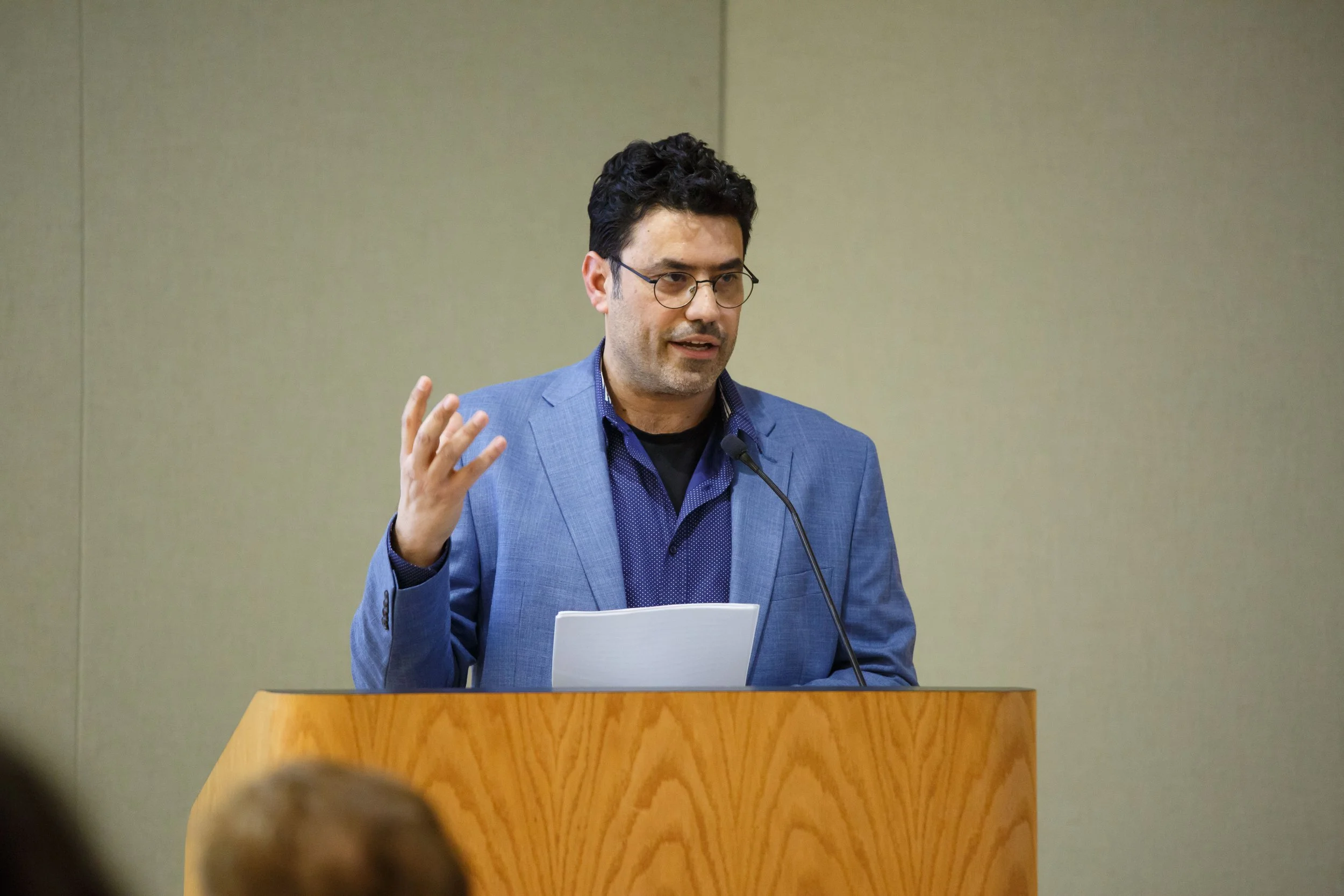 Professor Yuval Evri giving a speech at a conference room.