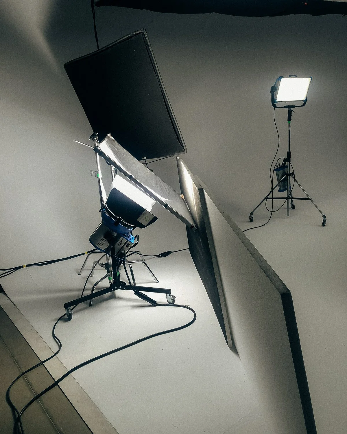 Photography studio setup with lighting equipment, a backdrop, and a camera.